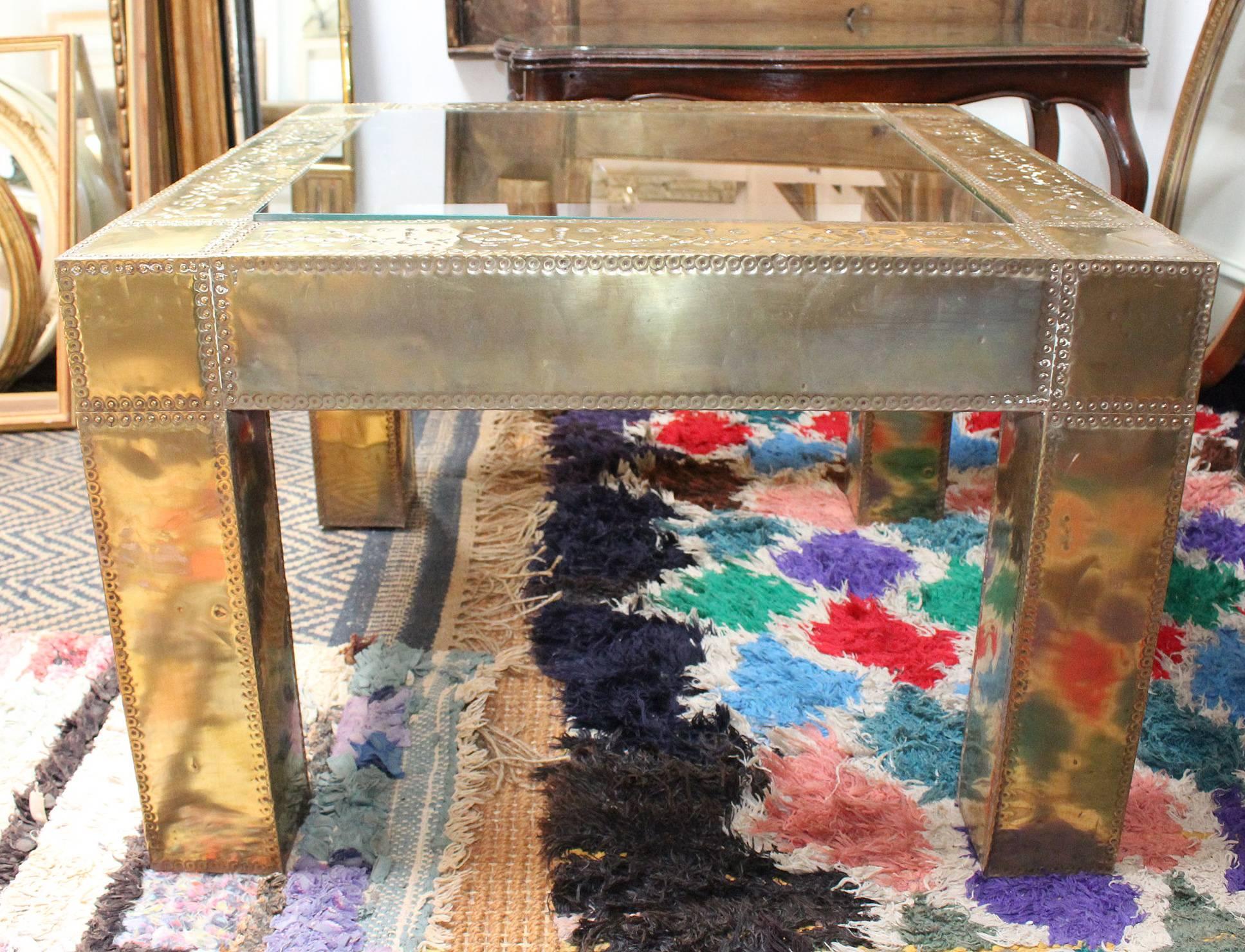 table d'appoint carrée espagnole des années 1970 en laiton et verre, fabriquée en travaillant à la main des panneaux de laiton pour couvrir un cadre en bois et surmontée d'un panneau de verre.

     