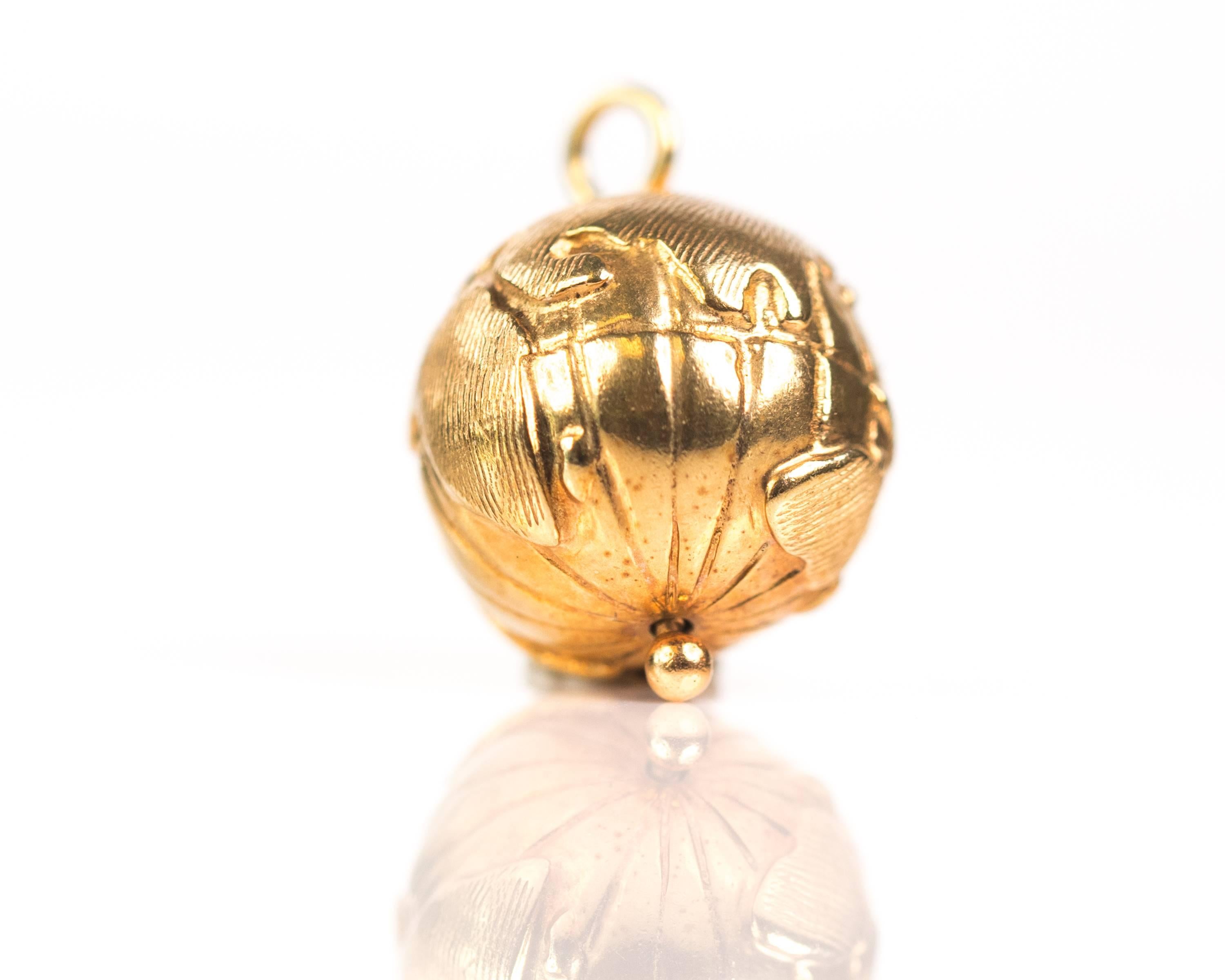 1970s Spinning Globe Charm - 14 Karat Yellow Gold

This 14 Karat Yellow Gold Globe spins on it's axis and features the continents and longitude lines. The bail pin runs through the center of the globe providing an axis on which the orb spins.