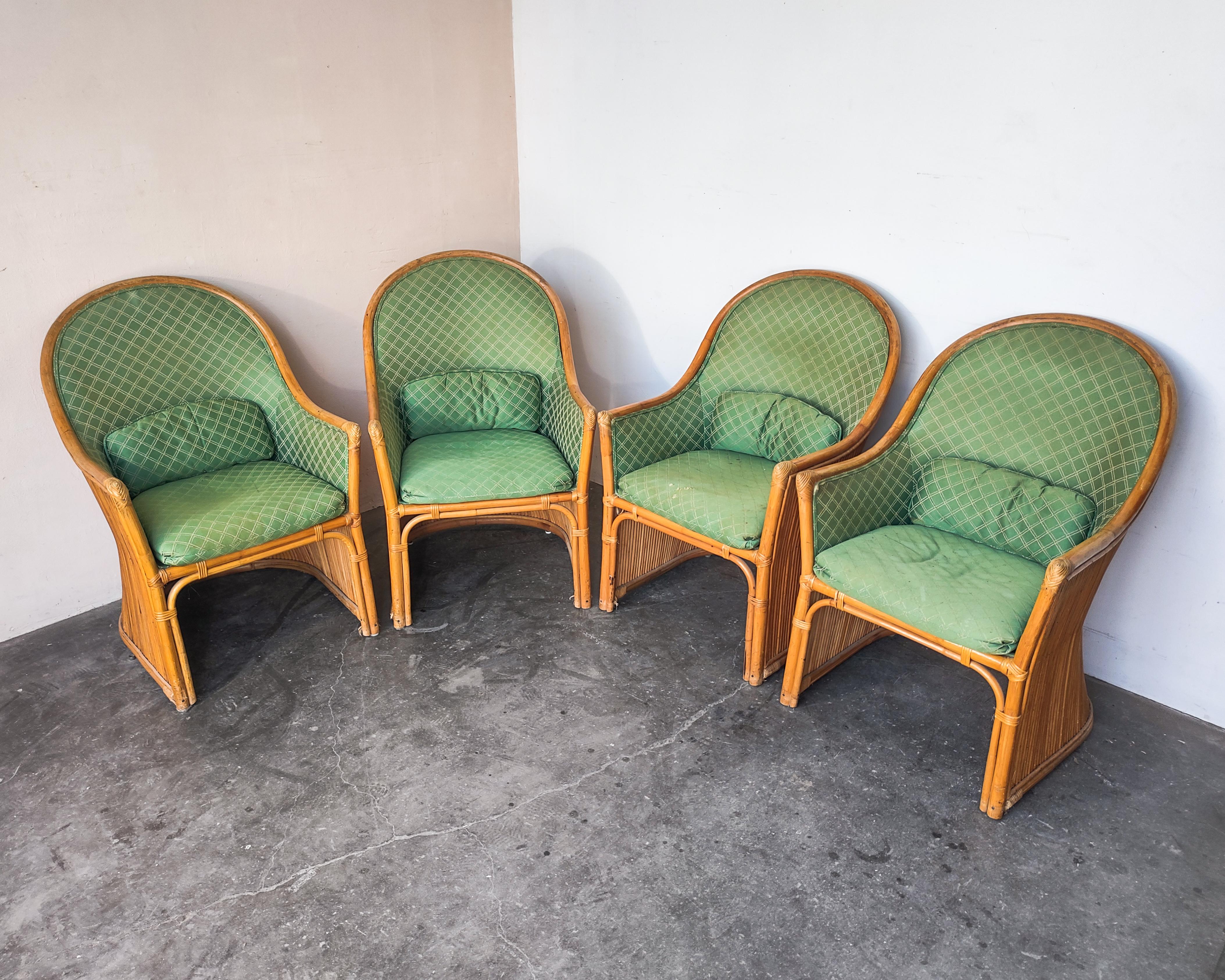 Sculptural rattan dining chairs with a lovely hourglass shape. Green satin upholstery is original and shows heavy wear with holes in some areas. Bolster pillows are removable. Overall great structural condition with some normal wear consistent with