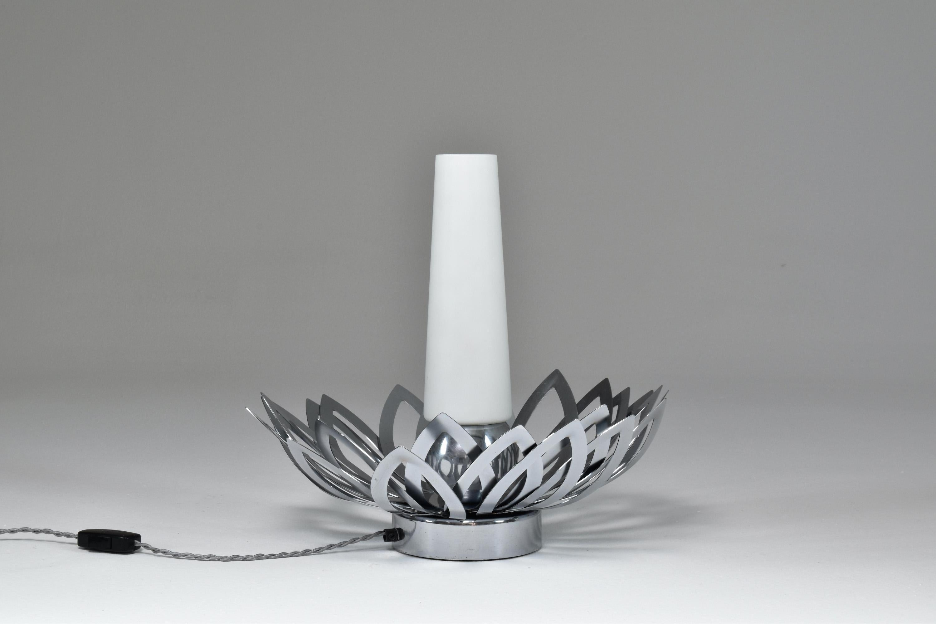 A highly original vintage statement table lamp designed and crafted by French artist Jacqueline Trocmé in the 1970s. The light resembling a flower is designed with beautiful leaves all around and a soft central opaline white glass shade in the