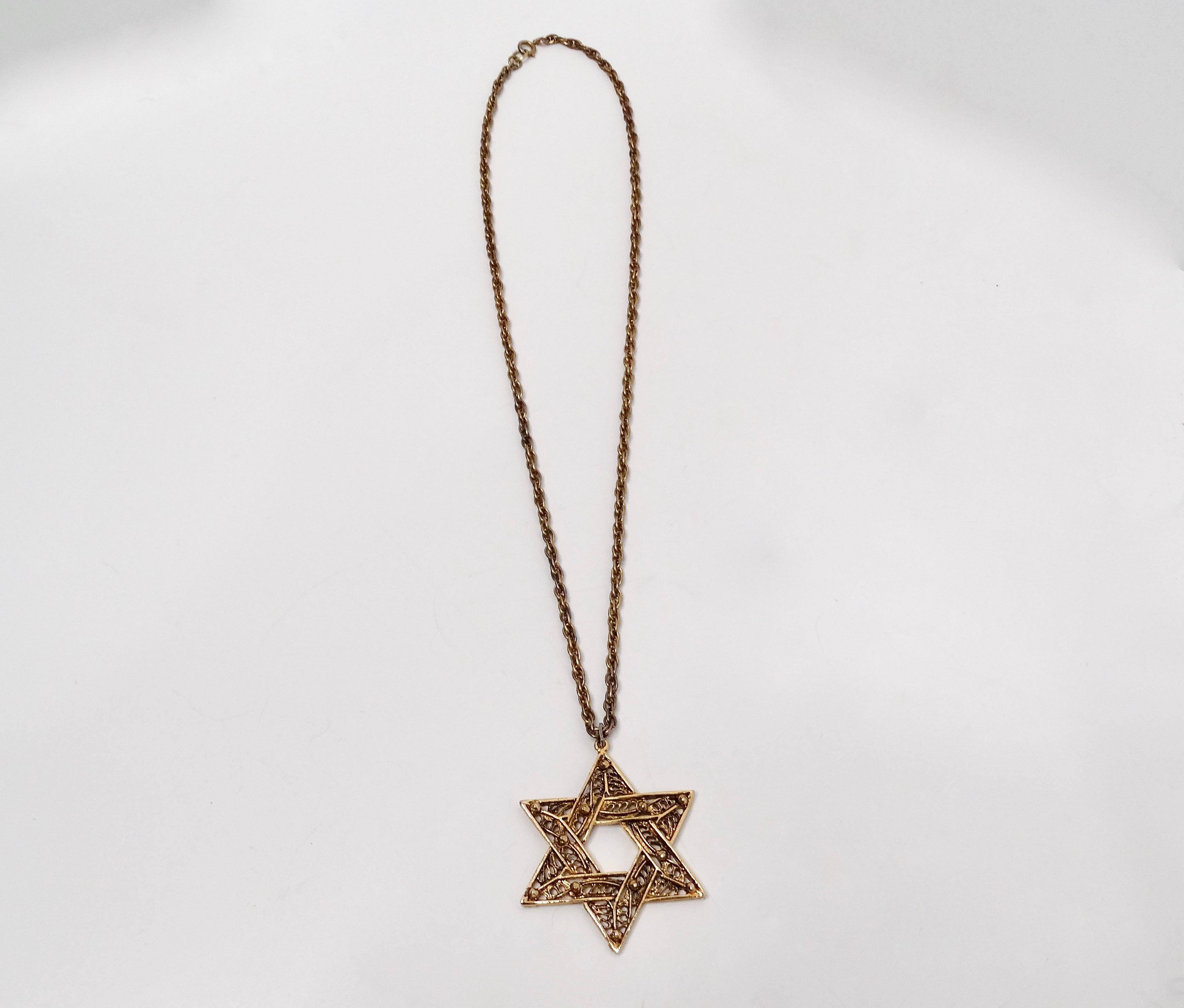 La collana con ciondolo a catena a forma di stella di David degli anni '70 in filigrana placcata in oro 14k racchiude l'eleganza del design vintage con i suoi intricati dettagli in filigrana e la lussuosa placcatura in oro. Questo pezzo forte è