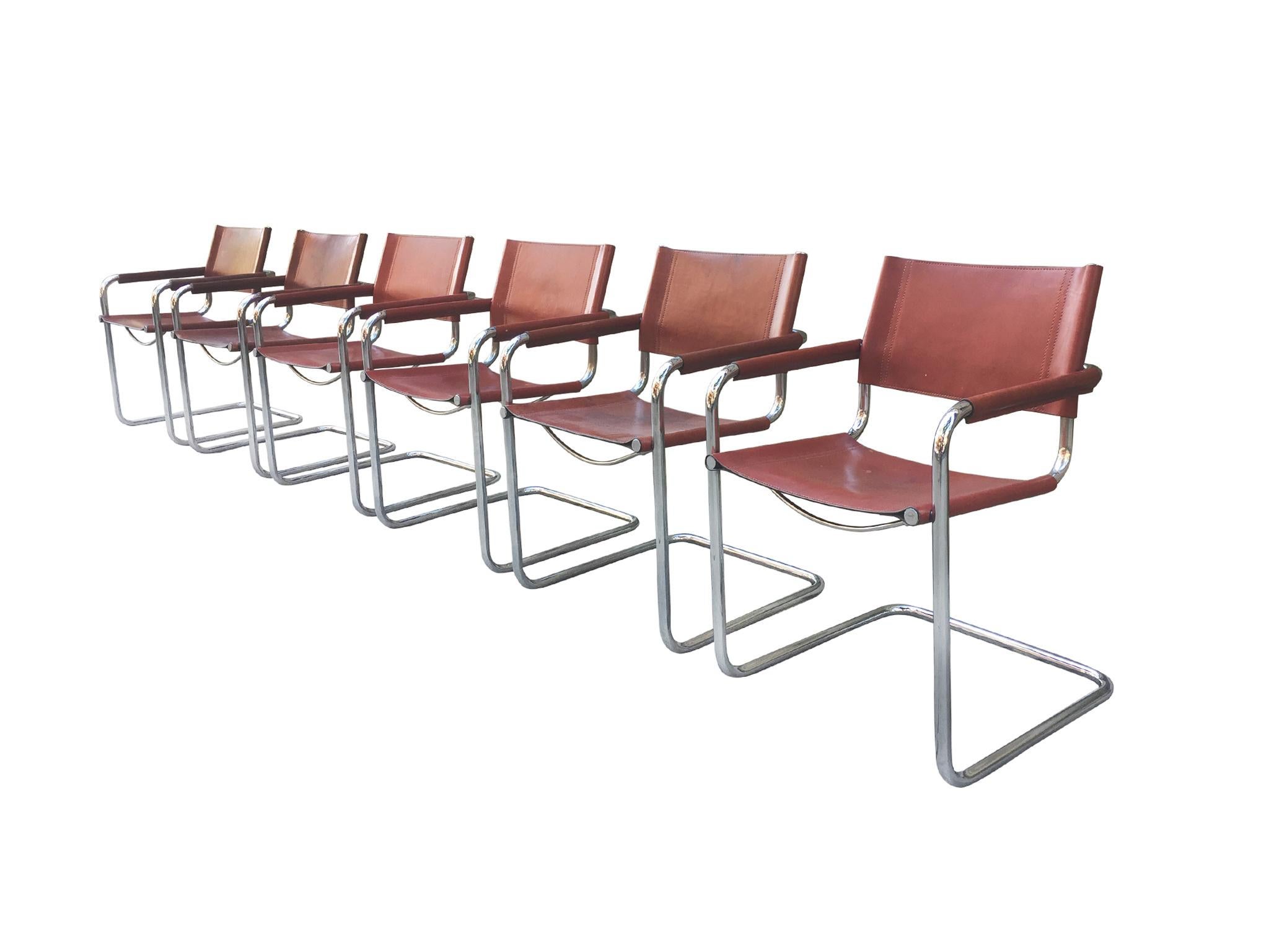 A handsome set of 6 dining chairs, made in the 1970s, with a nod to Bauhaus modernism, Matteo Grassi designs, and Campaign style furniture. The chairs consist of a chrome tubular frame and leather seating and back. The leather is stretched over the