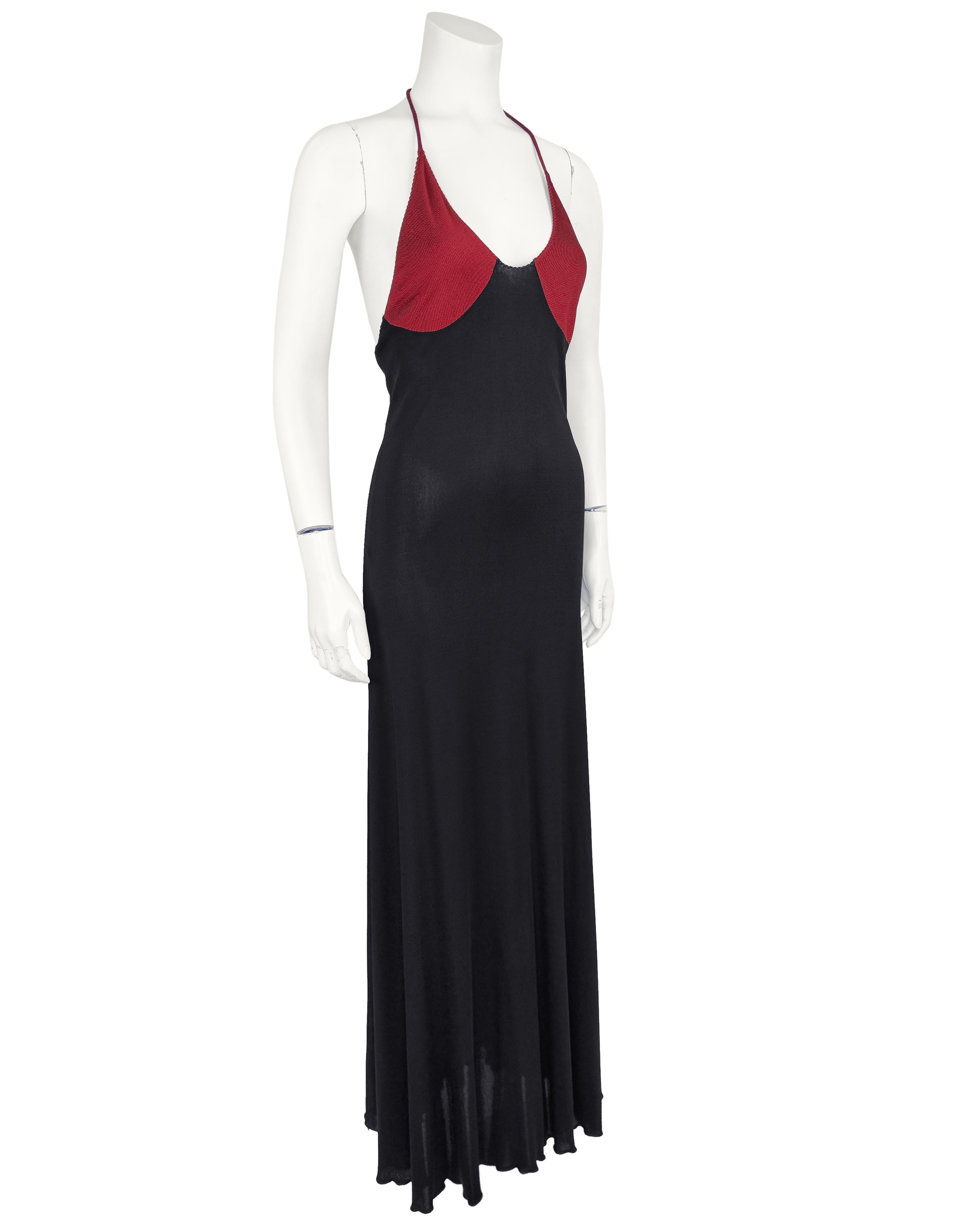 1970's Stephen Burrows black and burgundy slip style gown. Slinky and minimalist made in polyester, the care free fabric of choice for the youthful generation that wore these designs. Burgundy accent bra like bodice with halter style shoe string