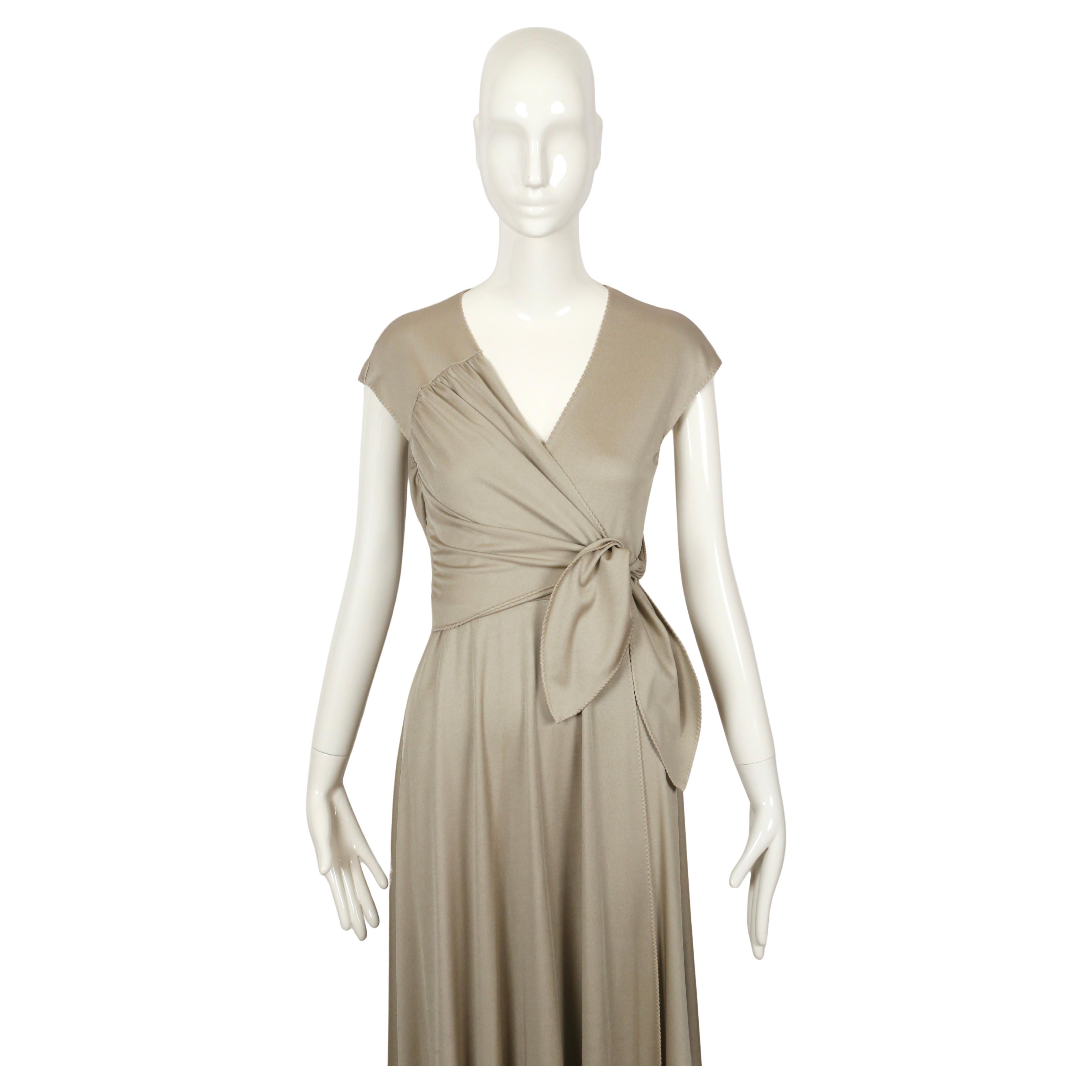 Oyster-grey jersey wrap dress with asymmetrical tie at bodice and 'lettuce-edge' edges designed by Stephen Burrows dating to the 1970's. Labeled a 10 however this fits very small and would best suit a US 2-4. Dress was not clipped on the size 2