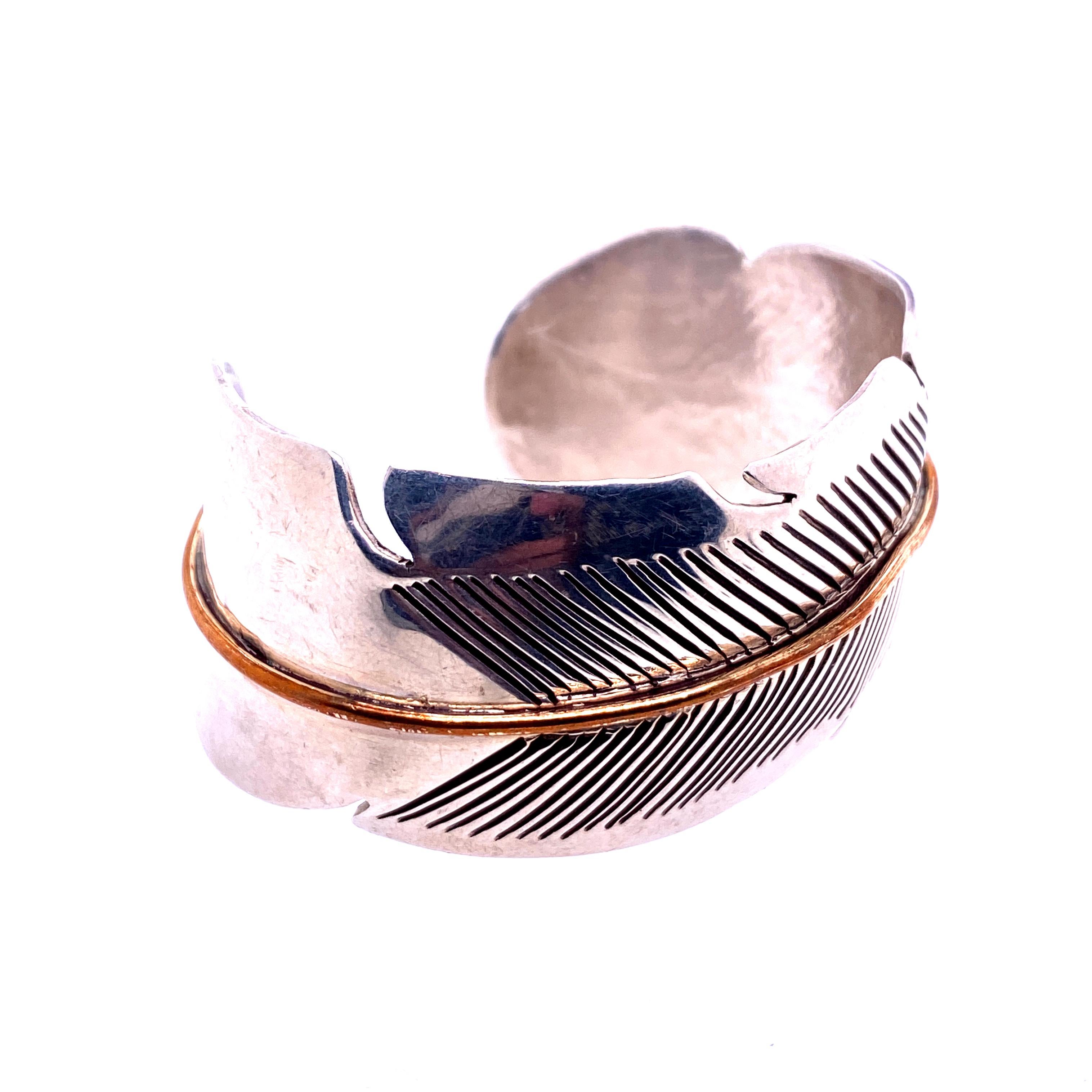 One sterling silver cuff bracelet with a feather engraving and copper line center.  The cuff measures 1.25 inches wide. Circa 1970s