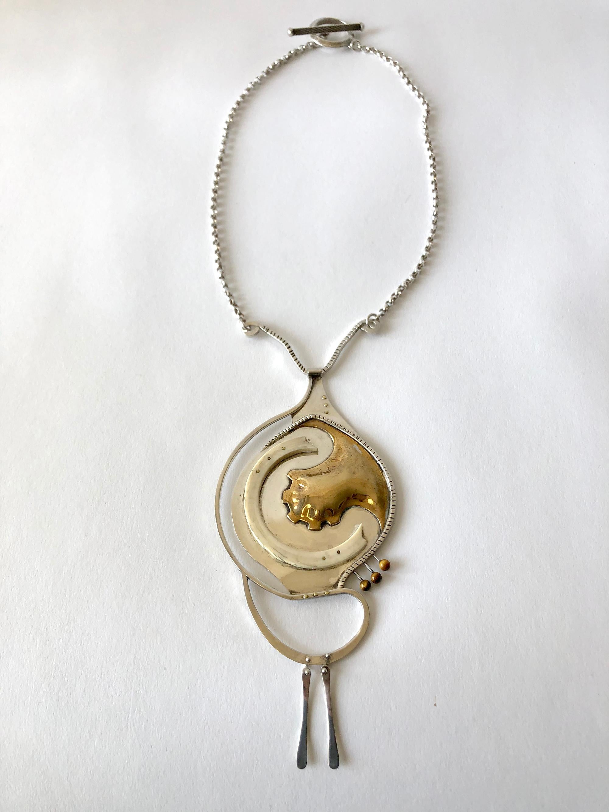 Collier des années 1970 en argent sterling et or, fait à la main, avec un œil de tigre et des clous en or.  Le pendentif du collier mesure 7,5