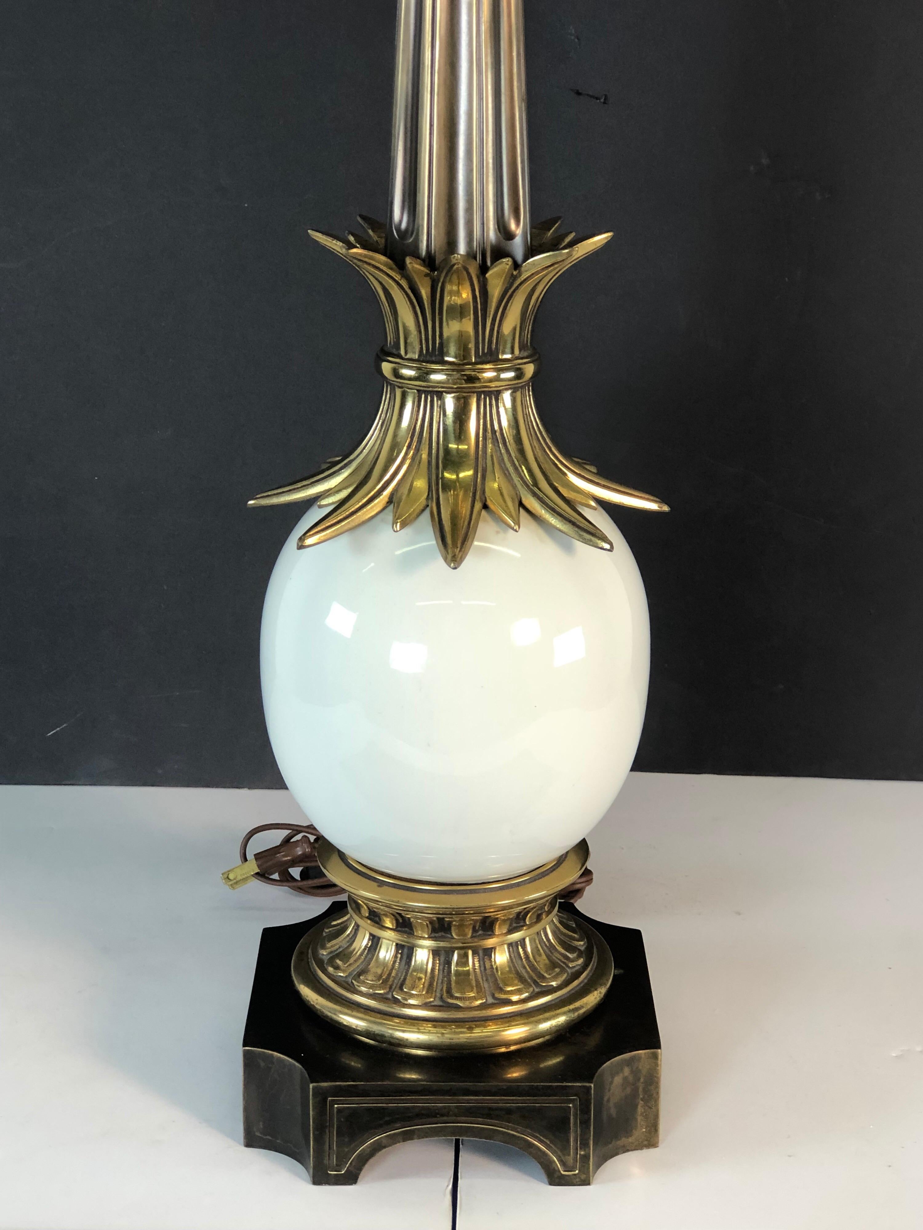 1970s Stiffel brass and ceramic table lamp on a bronze base with an accented leaf design. The lamp is wired for the US and in working condition. Socket, 17.5” height. Harp, 4” diameter x 9” height. The shade is not included.