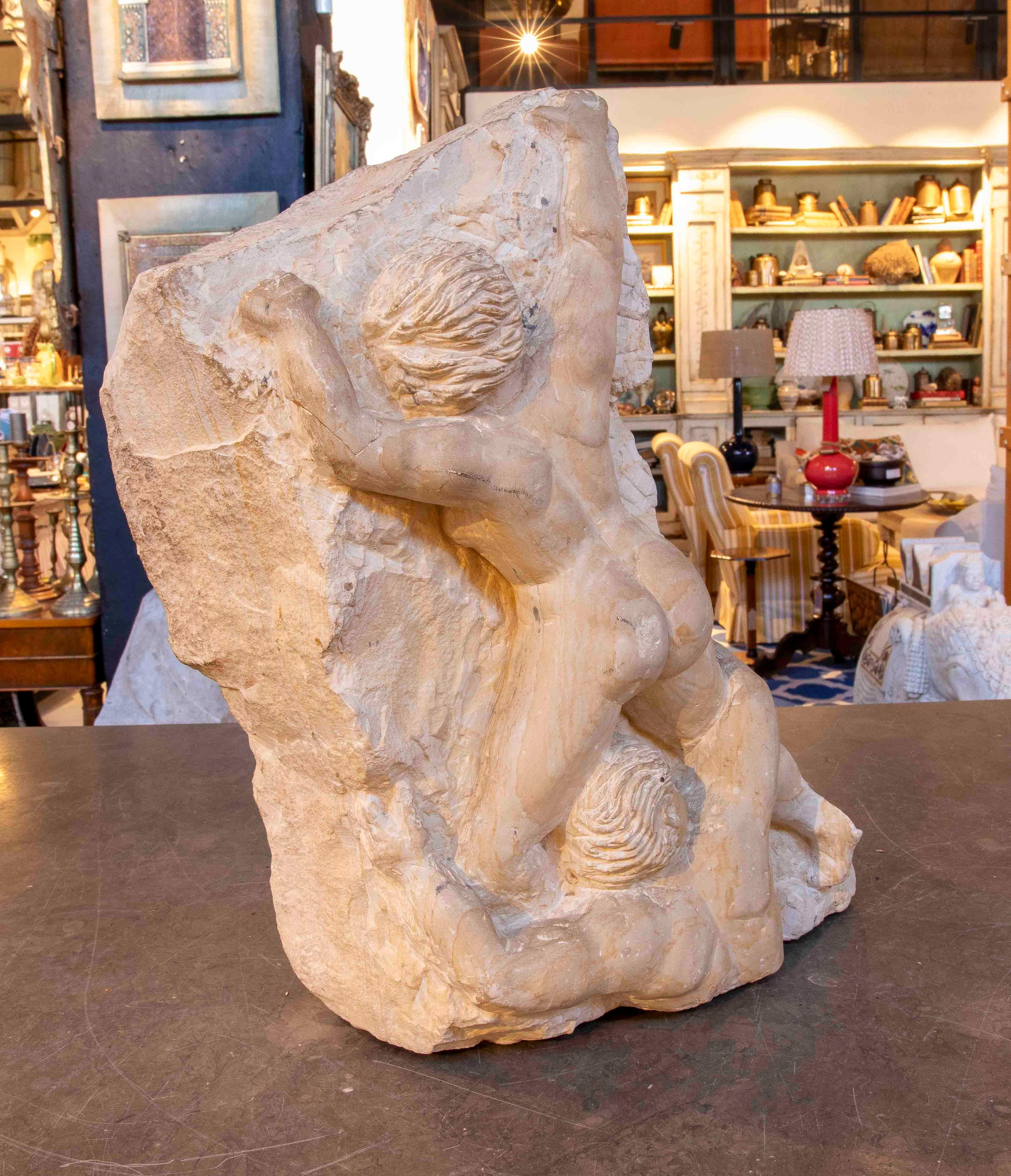 Imponente scultura in pietra dell'artista francese A. Michel Bulard, che raffigura due figure maschili in ascesa, catturate in un momento di tensione e dinamismo. Il blocco conserva parte della sua superficie grezza, in contrasto con le figure