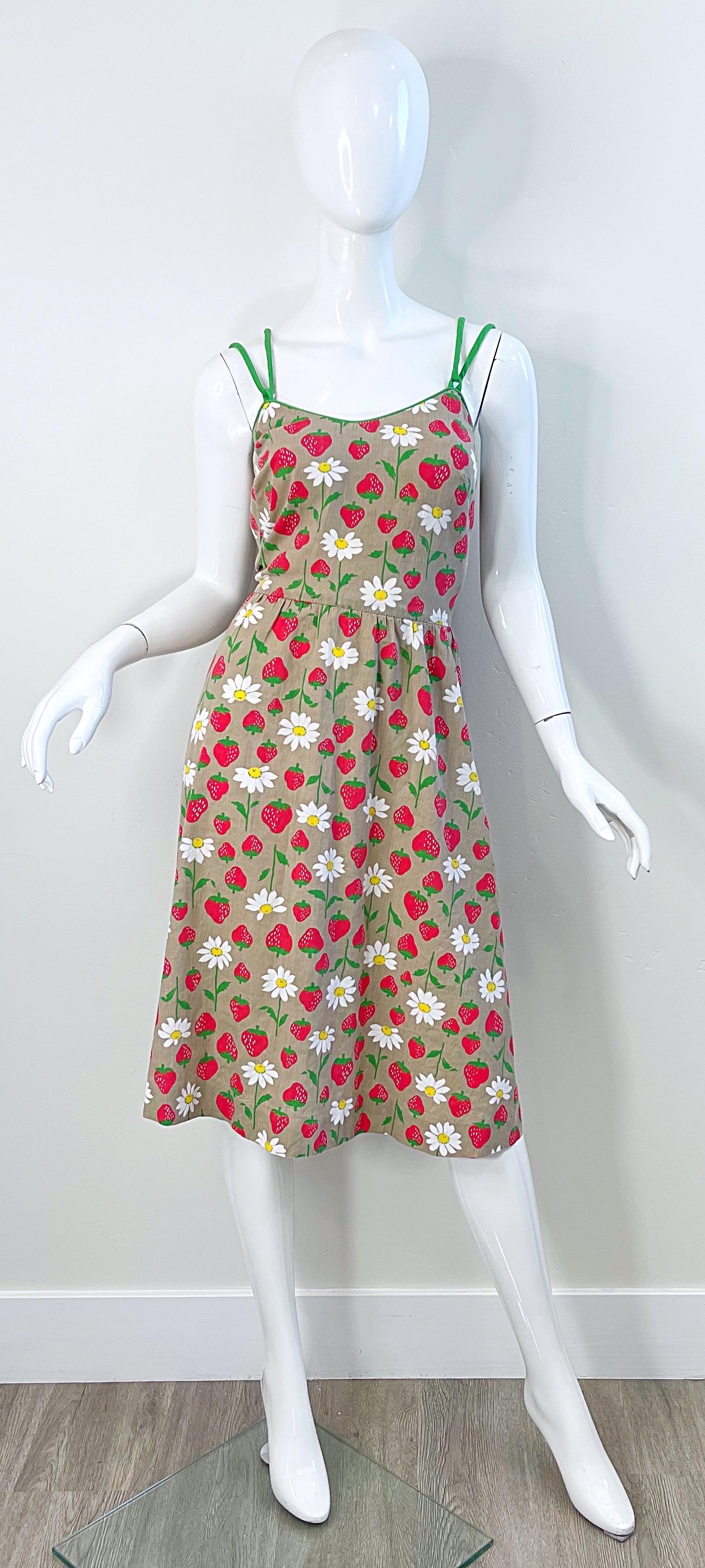 Robe de soleil chic en coton imprimé de fraises et de marguerites des années 1970 ! Ce modèle présente un corsage ajusté et une jupe évasée, qui peut également accueillir une crinoline sous la jupe pour plus d'ampleur. Poches de chaque côté des