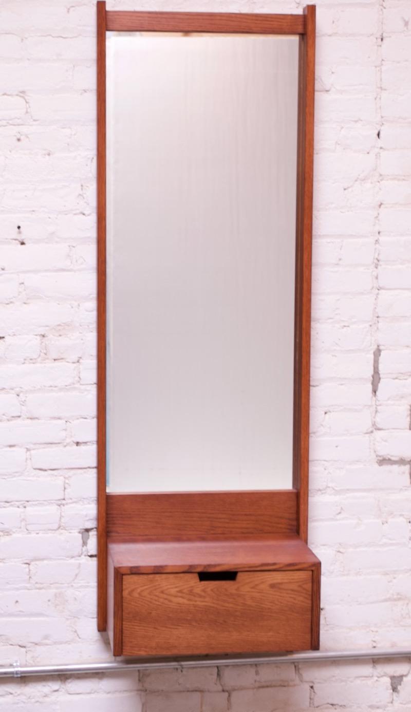 Stained-oak wall mirror with drawers designed and crafted by noted architect and furniture maker, Charles Webb (Cambridge, MA), circa 1970s. Mirror is clean and free of wear; wood has been refinished. Overall, excellent, vintage condition.
Retains