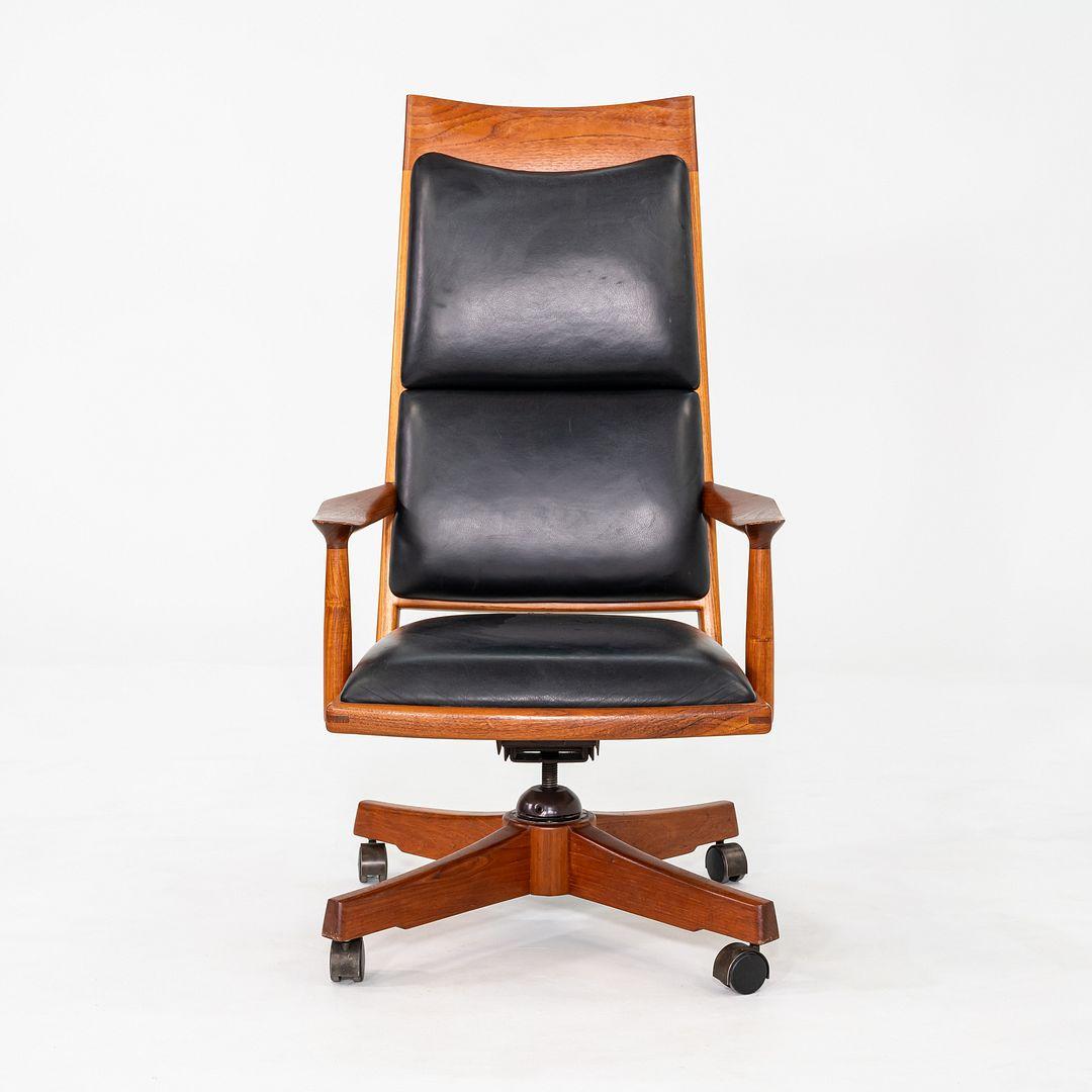 Il s'agit d'une chaise de bureau personnalisée, fabriquée en studio, conçue et produite par l'artiste John Nyquist dans les années 1970 aux États-Unis. La structure de la chaise est en teck et l'assise et le dossier sont recouverts de cuir noir. La