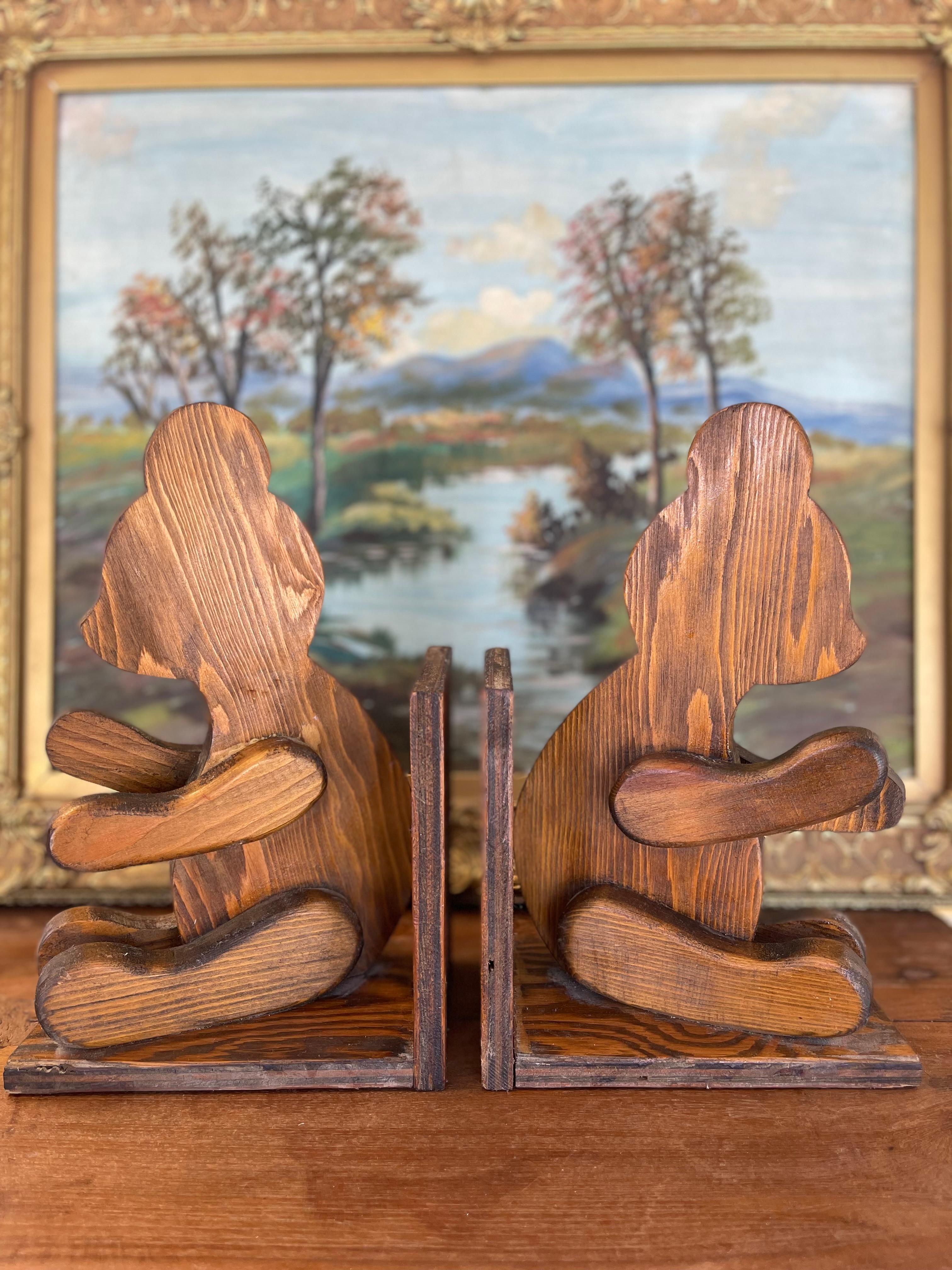 Charmante paire de serre-livres vintage en bois sculpté à la main représentant des ours assis, probablement fabriqués dans les années 1970. Chaque serre-livre est façonné individuellement en bois massif avec des éléments en bois superposés créant un