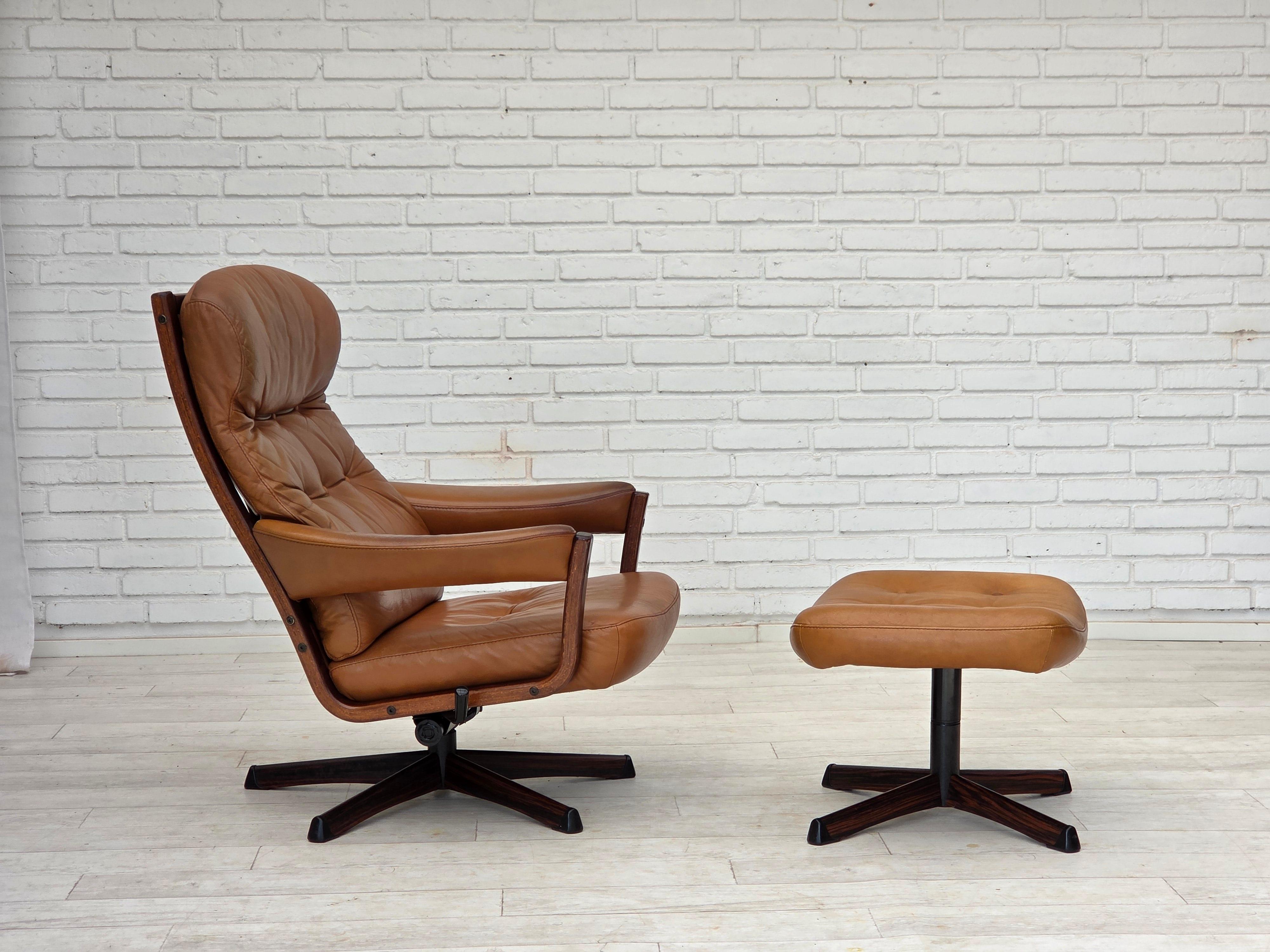 Anni '70, design svedese di Gote Möbler. Sedia girevole con poggiapiedi, con funzione di regolazione e dondolo. Pelle marrone originale per mobili, legno curvato, tela. Condizioni originali buone: nessun odore, nessuna macchia e struttura stabile.