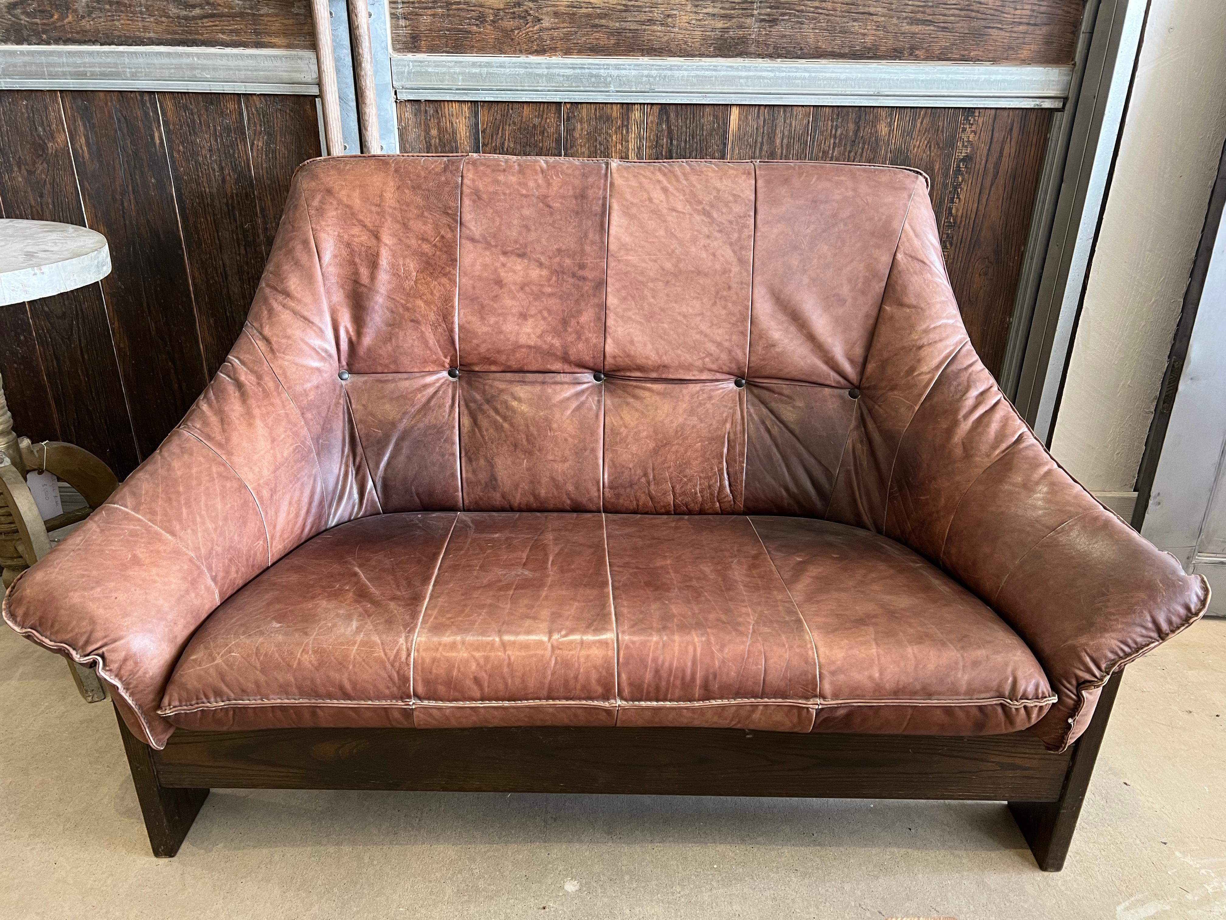1970’s Swedish leather settee with wood base. Matching sofa and lounge chair are available.