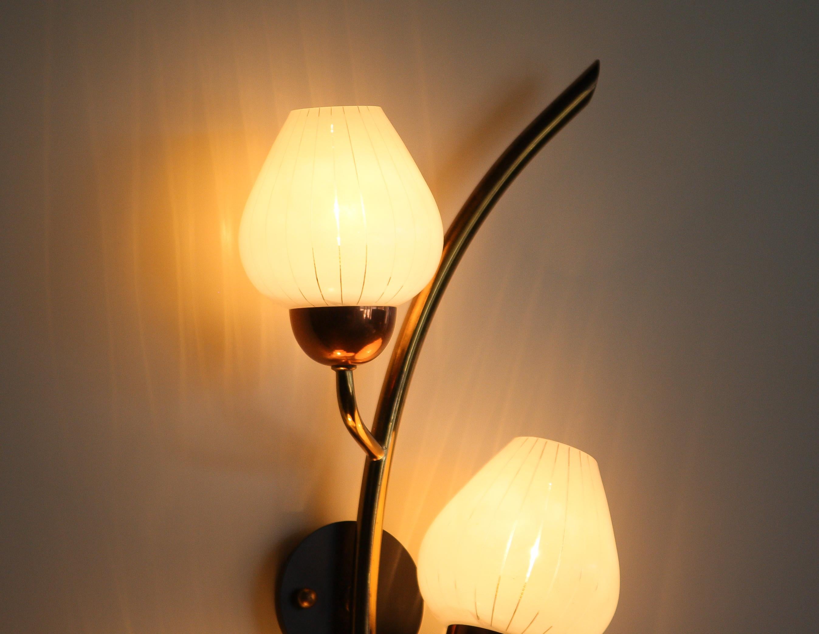 Beautiful brass wall lamp from Sweden.
This lamp consists of a copper base with five white glass shades.
The shades have transparent lines making it a nice shining light.
The lamp is in a very nice and functional state.
Period 1970s
Dimensions: