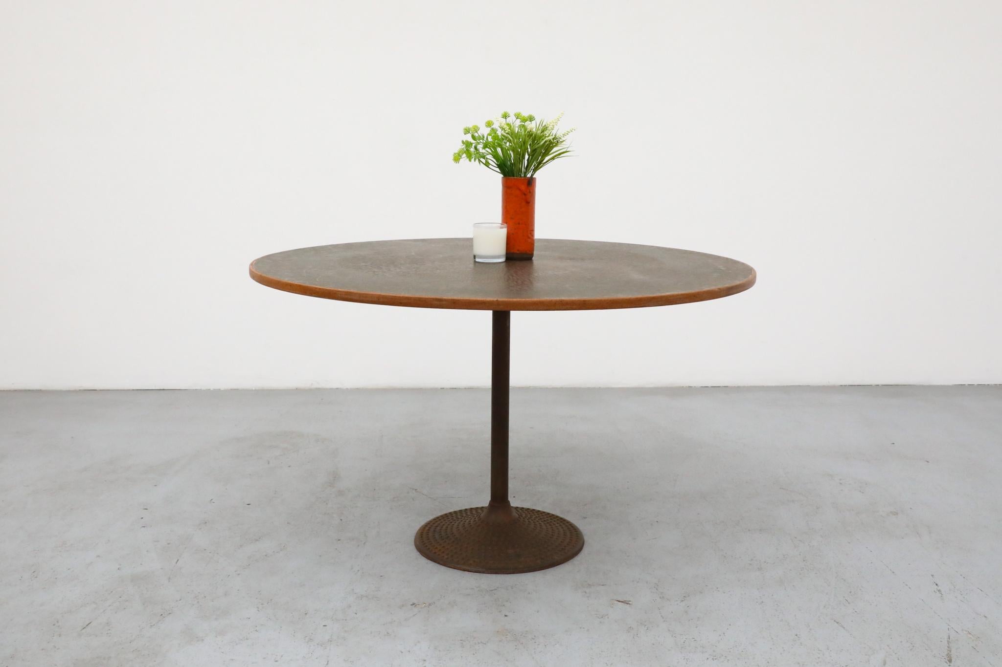 A striking Swedish pedestal dining table from the 1970s, featuring a unique round, embossed copper top with a warm, inviting patina. This captivating surface rests atop a lighter wood core, bordered by its natural wooden edge, and finished with a