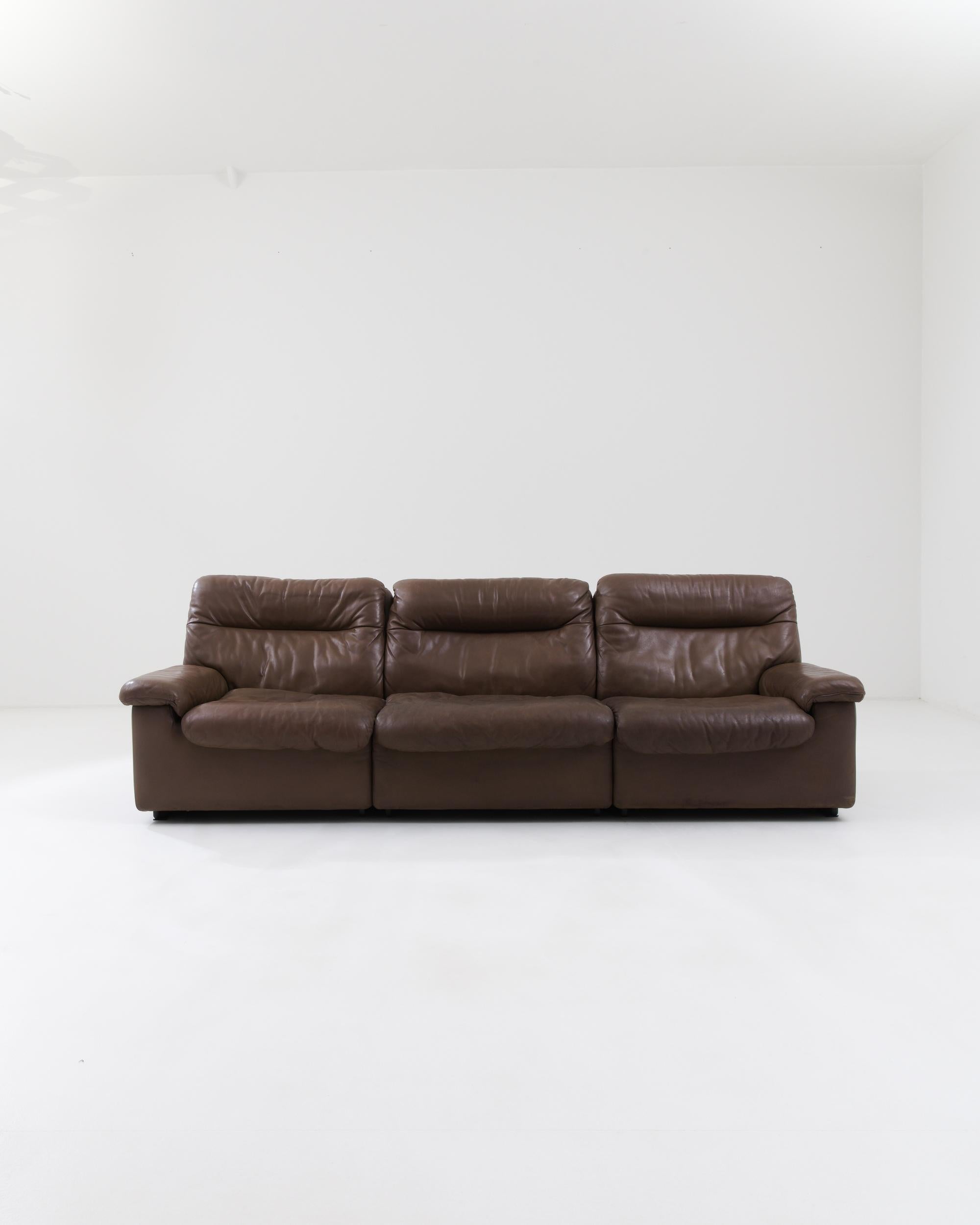 A leather sofa created in 1970s Switzerland. This marvelous leather sofa was made by De Sede, a furniture maker who has been renowned for over fifty years of ground-breaking handcrafted leather pieces. The rich brown leather and extra wide,