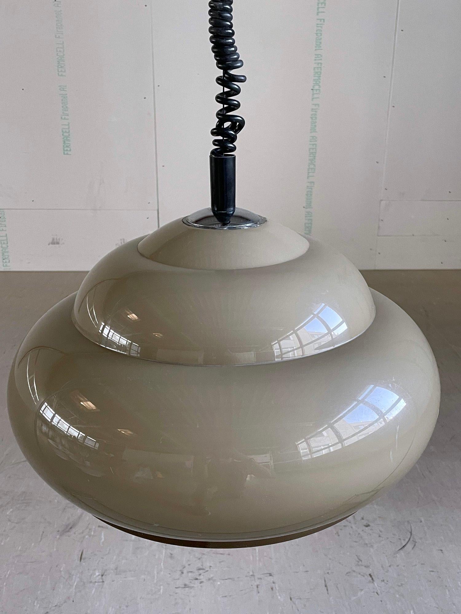 Lampada a sospensione Regent degli anni '70. Paralume in acrilico beige con cavo regolabile in altezza e maniglia cromata per sollevare o abbassare la lampada a piacimento. Un'illuminazione calda e piacevole.
Nello stile di Harvey Guzzini. Max 100W.