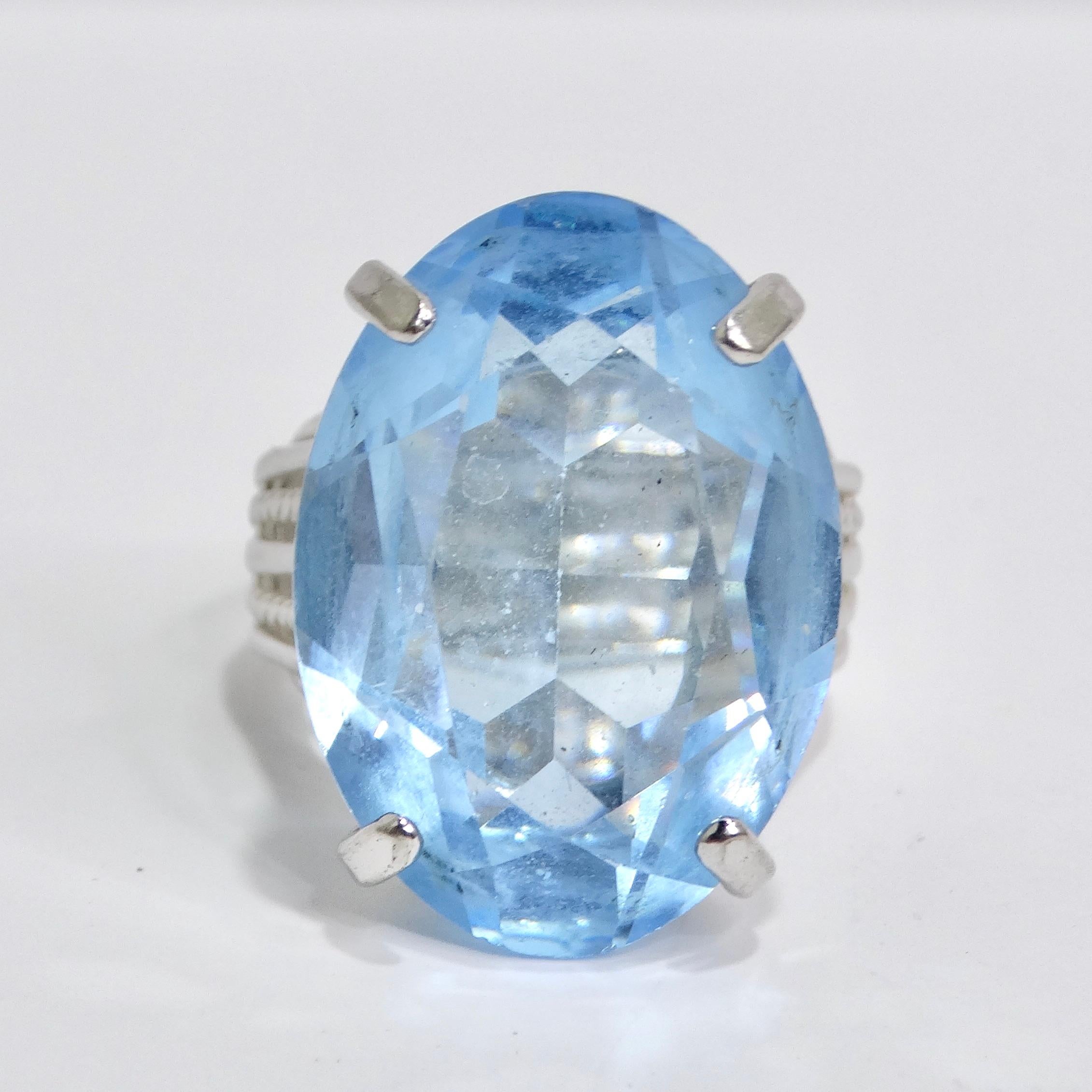 Step into the enchanting world of the 1970s with our magnificent Synthetic Aquamarine Silver Plated Cocktail Ring. This vintage-inspired masterpiece features a generously sized, eye-catching synthetic aquamarine stone set in a silver-plated band. A