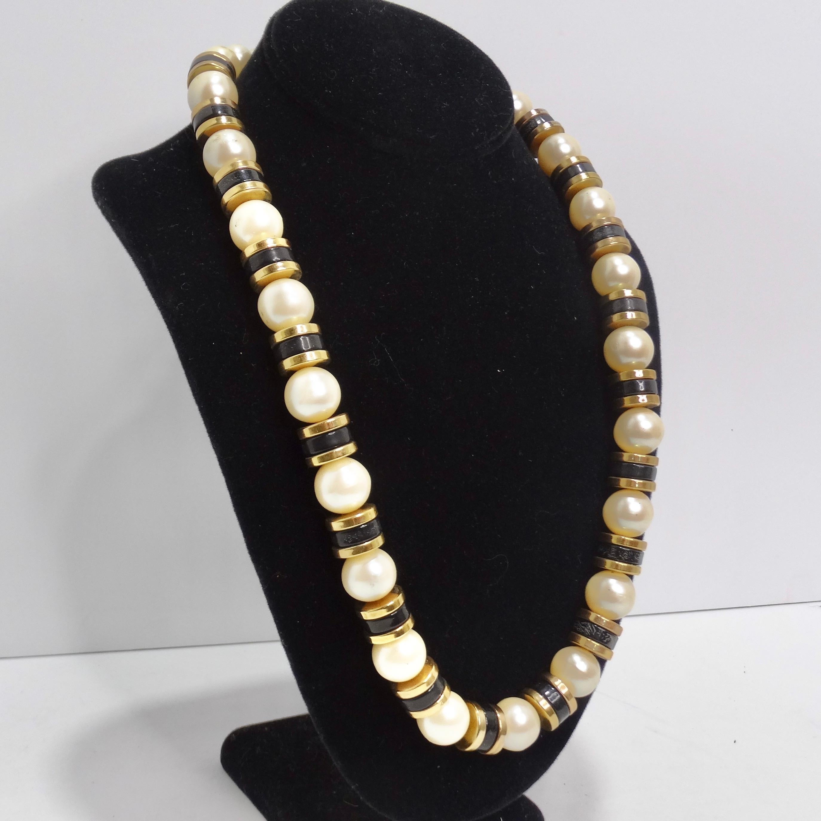 Tauchen Sie ein in die Welt der Vintage-Eleganz mit unserer atemberaubenden 1970er Synthetik-Perlenkette. Diese Halskette aus großen synthetischen Perlen und kontrastierenden schwarzen und vergoldeten Perlen ist ein vielseitiges Accessoire, mit dem