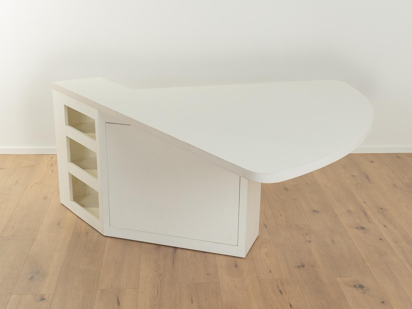 Versatile table in Bauhaus design. Model M1 by Stefan Wewerka for Tecta. Draft from 1979. High-quality construction consisting of a base with one door, two shelves, three open compartments and a table top in white lacquered ash veneer. The table can