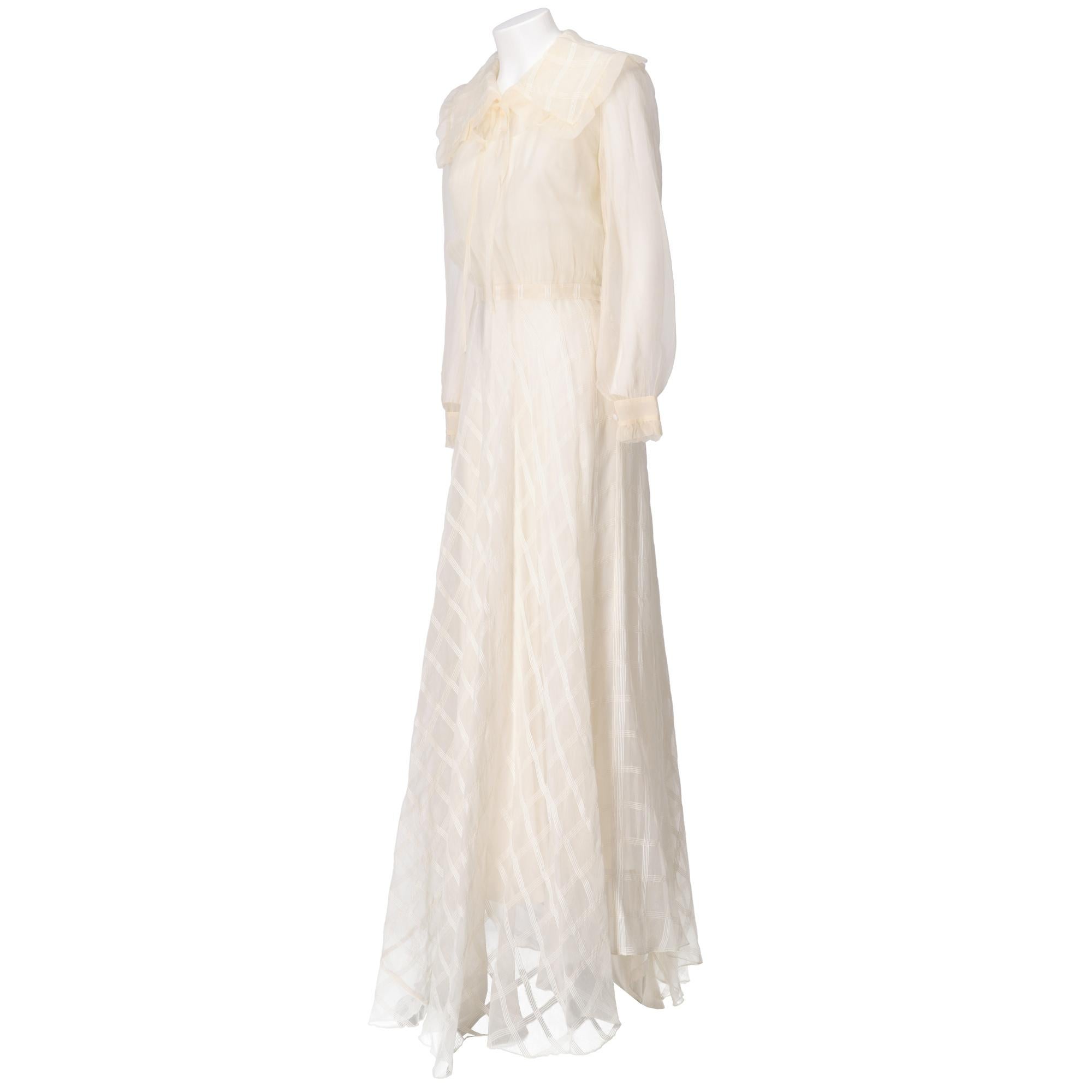 Ivory tailored wedding dress in semi-transparent fabric with tone-on-tone tartan pattern and white slipdress with train, wide collar with rouge on the hem and adjustable ribbon, cut at the waist, long sleeves with buttons on the cuffs, long full
