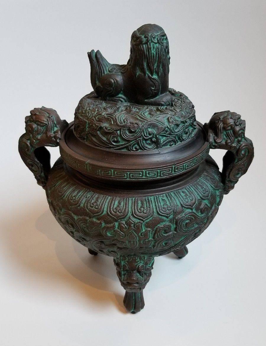 1970s Shang dynasty-style ice bucket, similar to designs by James Mont. The metal, three-footed ice bucket has a vintage green patina and turquoise plastic liner. Marked 