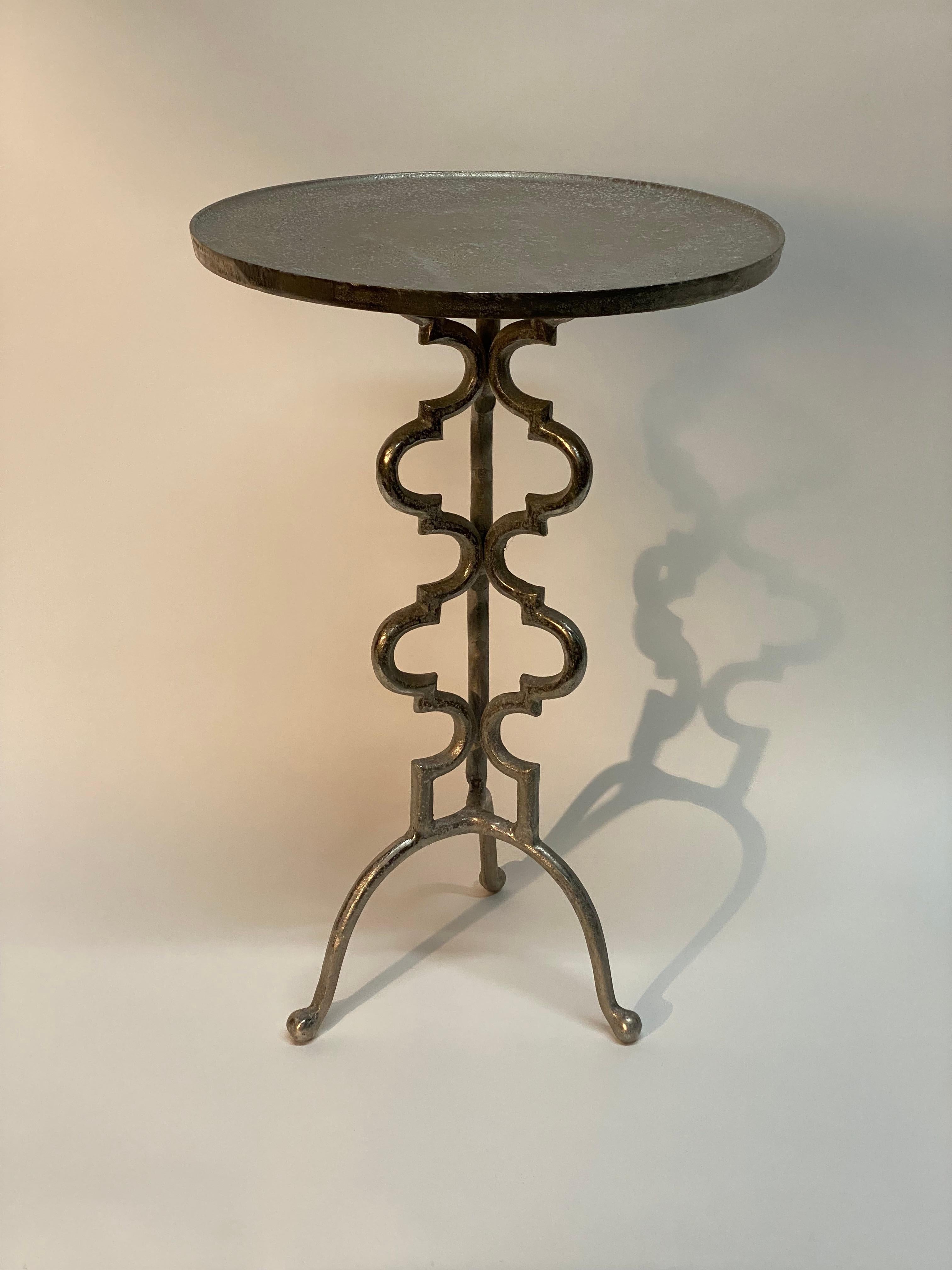 Tall cast aluminum tripod base accent table. An excellent example of Brutalist period piece. Slightly recessed round top with a nicely reticulated designed column supported by three curved legs ending with rounded ball feet. Endless uses as a plant