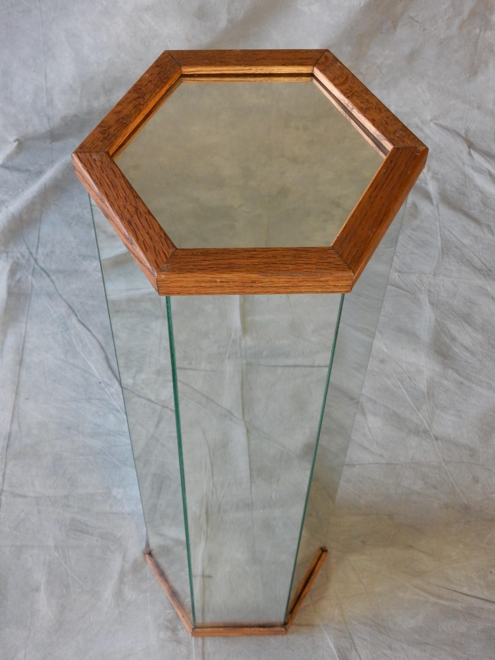 Un grand piédestal de forme hexagonale vers les années 1970.
Garniture en bois de chêne massif sur le dessus et le dessous
encadrer les 6 panneaux latéraux et le plateau en miroir.
Cette pièce est solide. 
La surface supérieure mesure 7-1/2