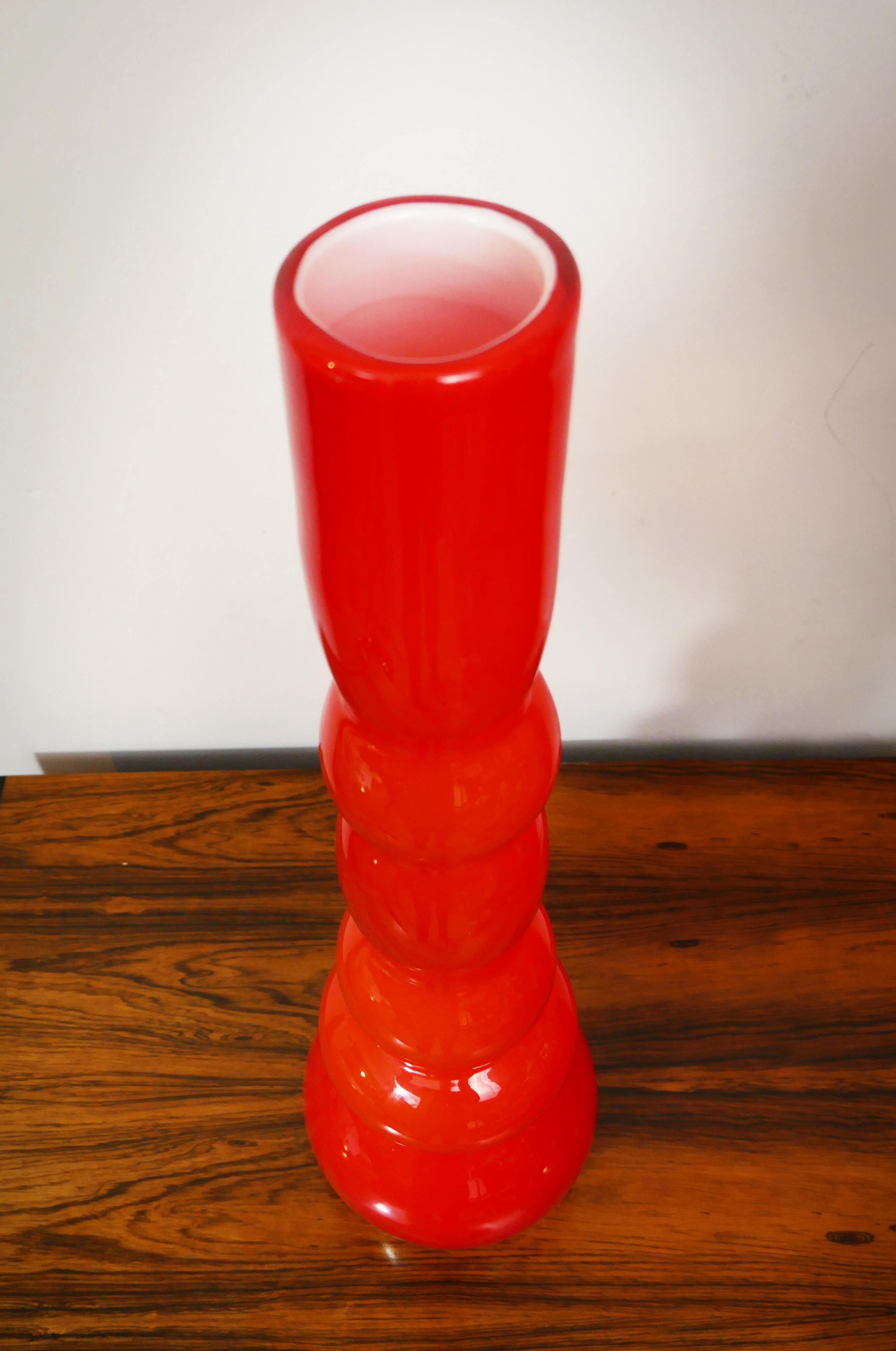 A tall, bulbous, sculptural 1970s orange cased glass vase. The designer is unknown but it's similar in style to Danish glassworks Holmegaard.