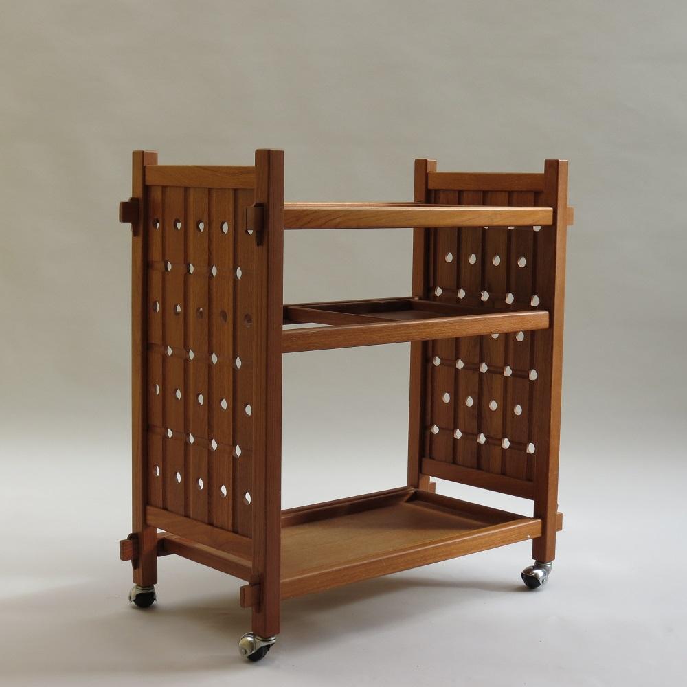 A very nice Teak trolley, one off bespoke made, possibly a student piece.  Dates from the late 1970s, possibly early 1980s. Has both secessionist and Japanese style influence to the design. 

The three trays are all removeable allowing for different