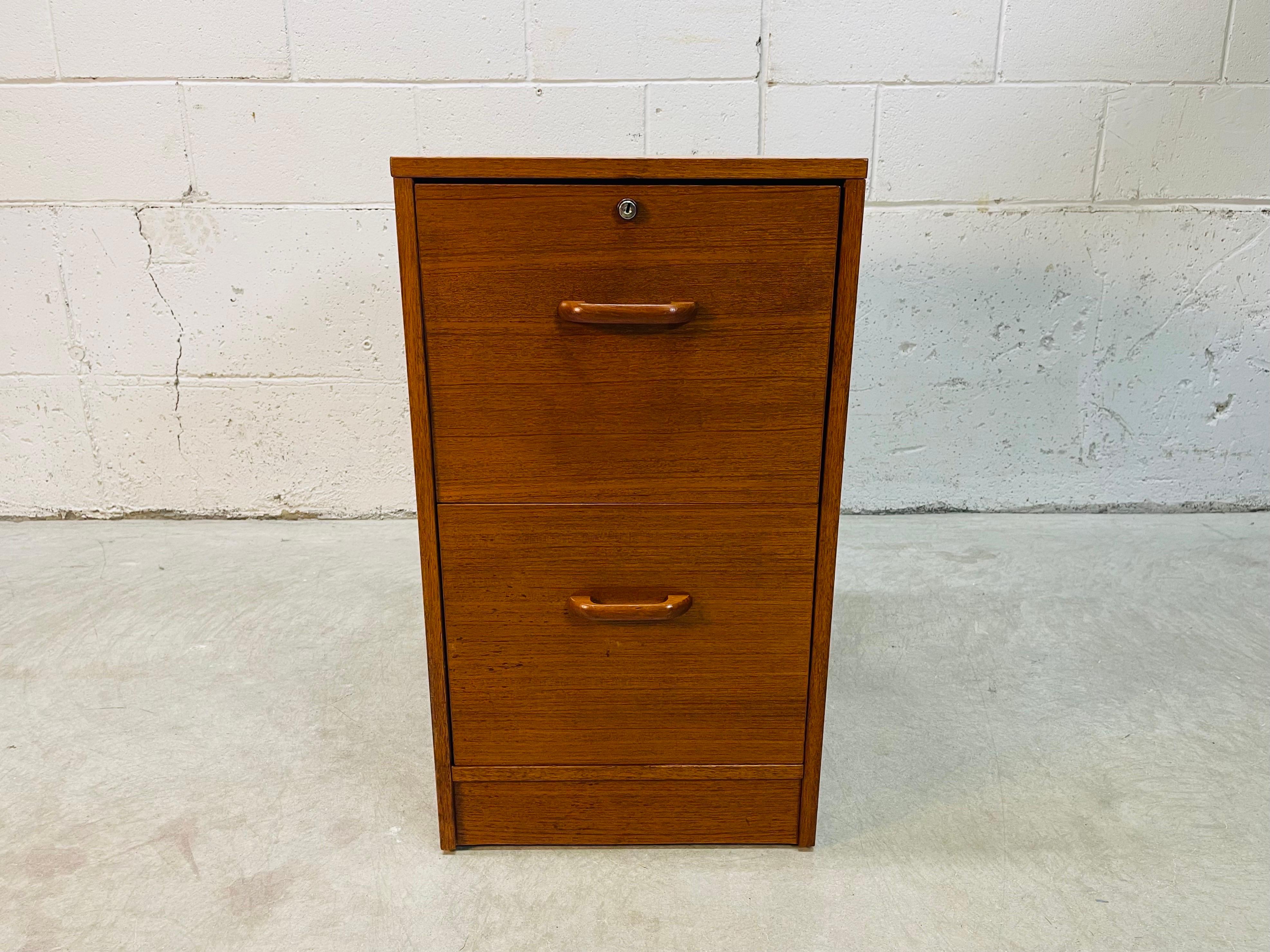 Vintage 1970s Danish teak wood two drawer filing cabinet. The drawers hold 12” size file folders. Drawers open and close freely. No key for the lock. Marked inside the drawer.