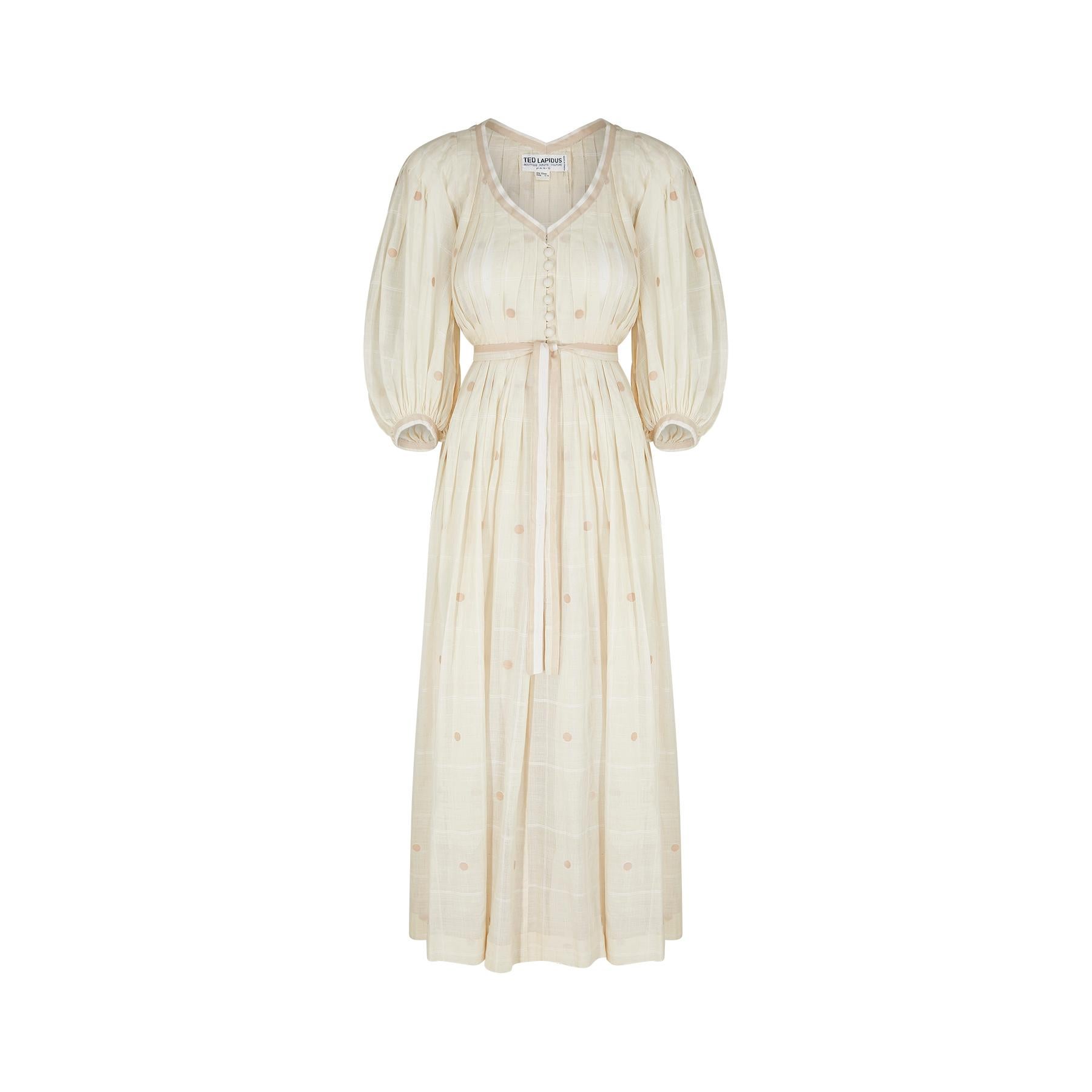 This 1970s dress is a phenomenal design piece from Ted Lapidus and from his flagship boutique line in Paris. It would have almost certainly been made by the same team as the haute couture collections and is in a wonderful cream checked muslin that