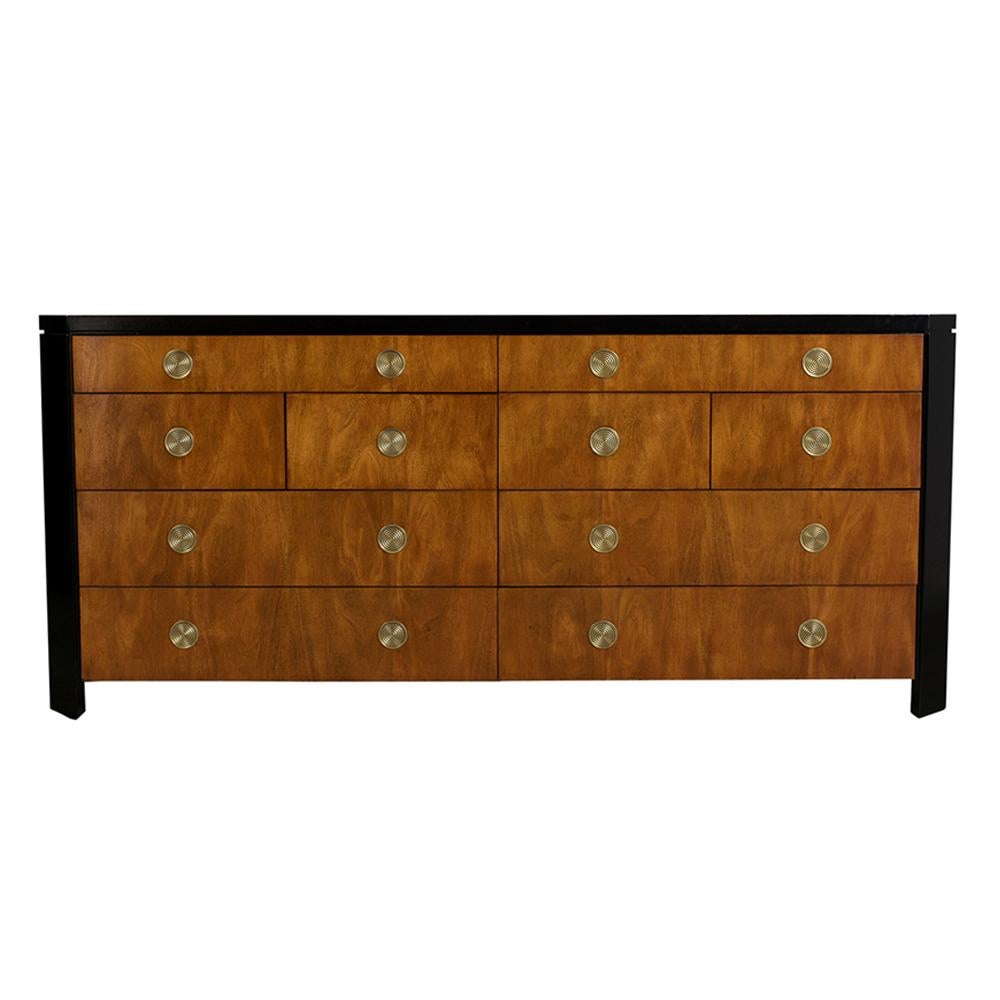 A large 1970s dresser by Baker made out of maple wood, this dresser has been professionally restored. It is a light walnut color with ebonized accents and a lacquered finish. This unique dresser drawer features an inlaid design along the top and