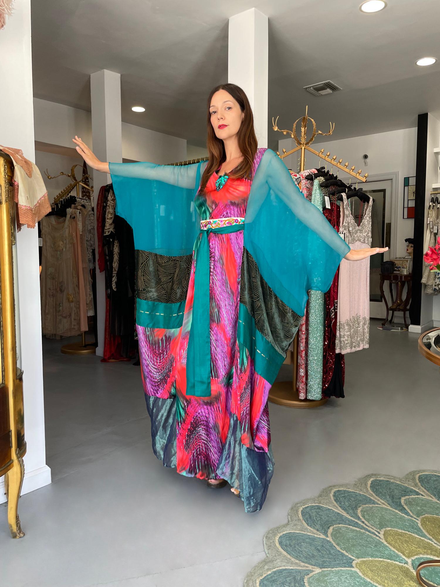 An absolutely gorgeous and highly coveted Thea Porter couture sheer silk-chiffon and colorful satin bohemian abaya caftan gown dating back to the early 1970's. This ultra rare garment is fashioned in the most beautiful psychedelic swirl print with