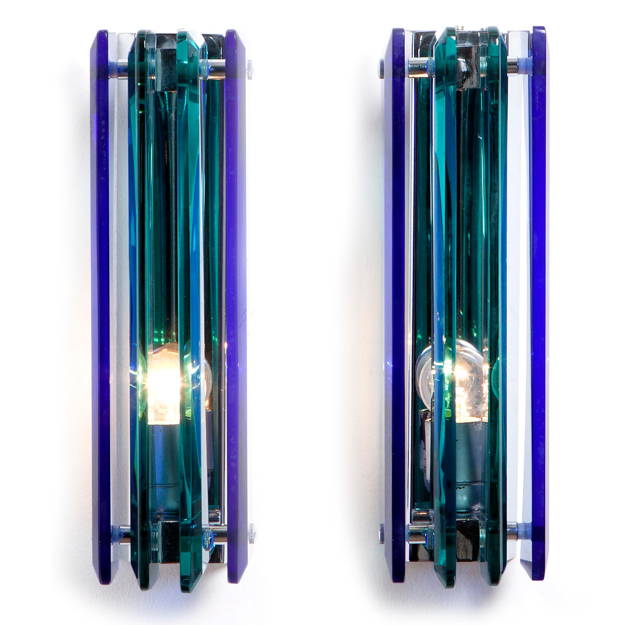 Stylish sconce with 2 dark blue and 2 clear thick glass planes attached to the chrome centre. One lightbulb, circa 1970s, slightly weathered glass. Attributed to Cristal Arte. Please note we have 3 pair in stock. one pair is of less quality,