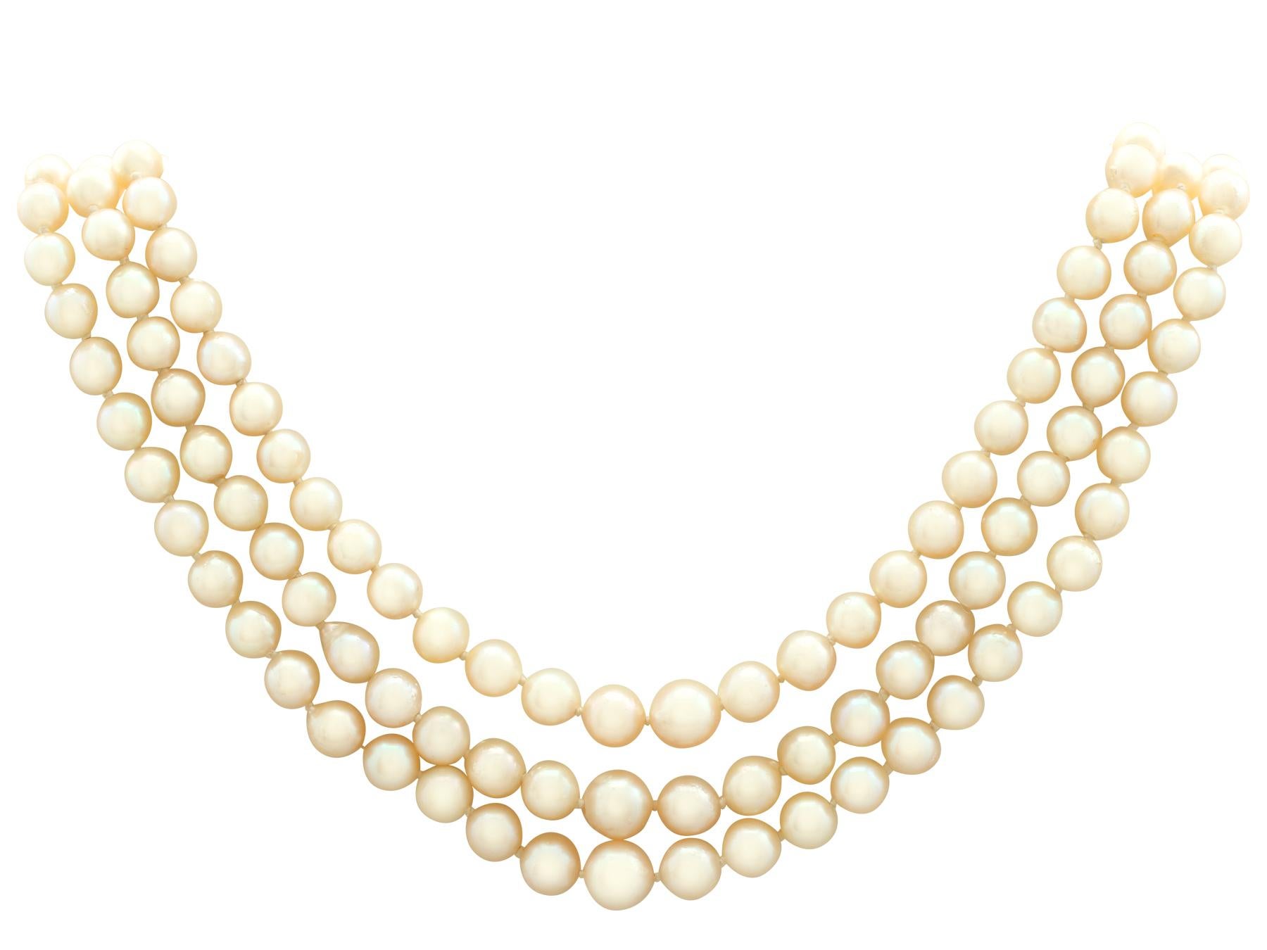 An impressive three strand cultured pearl necklace with seed pearl and 5.91 carat garnet, 9 karat yellow gold push fit clasp; part of our diverse pearl jewelry collections.

This fine and impressive 1970s three strand pearl necklace is composed of a