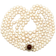 1970s Three Strand Pearl Strand with 5.91 Carat Garnet and Yellow Gold Clasp
