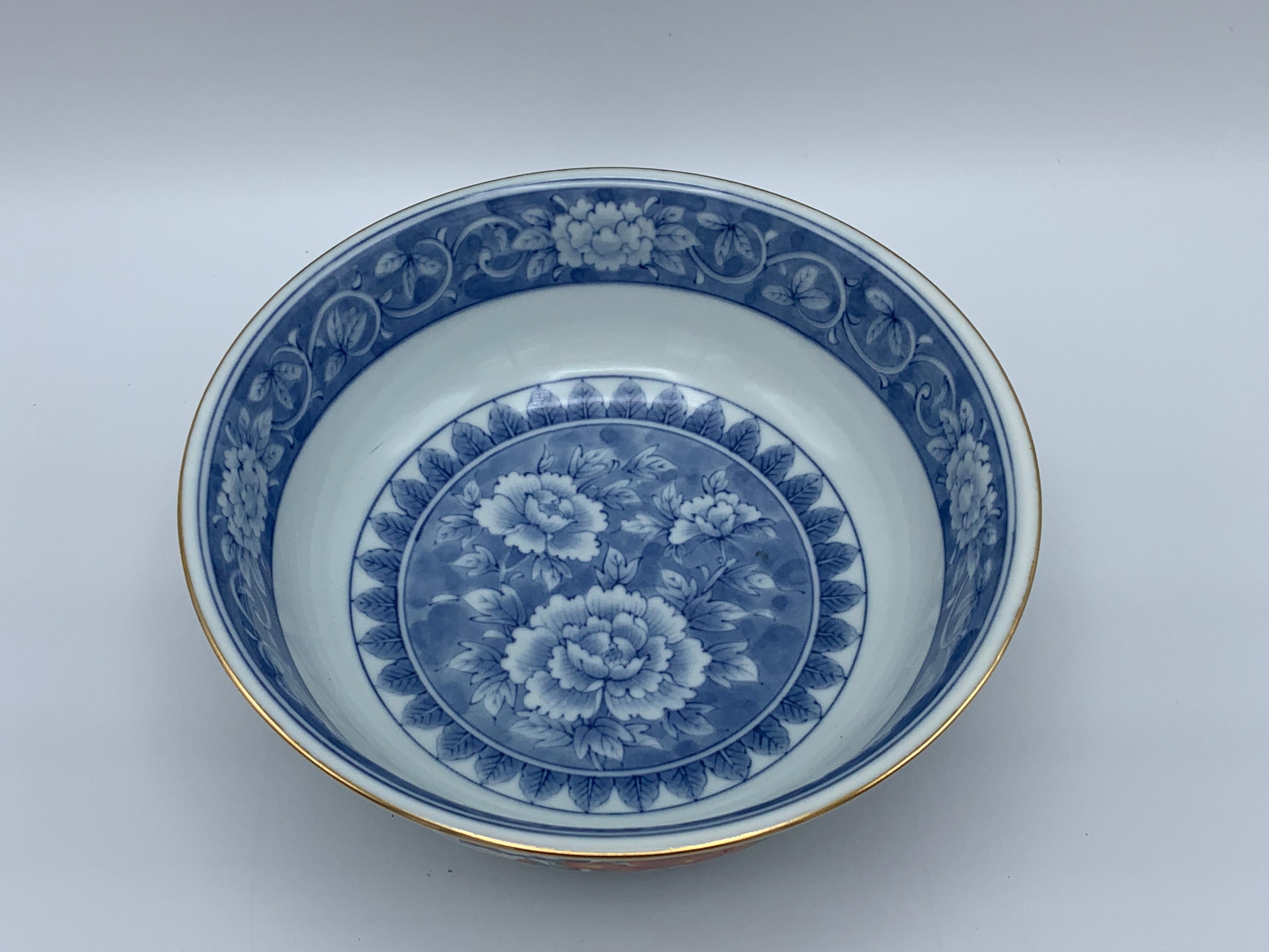 Offered is a gorgeous, 1970s Tiffany & Co. chinoiserie catchall bowl, a fresh take on the Classic antique Imari ware. The piece has a beautiful, blue and white peony background background with ornate orange florals, complimented by a gold rim along