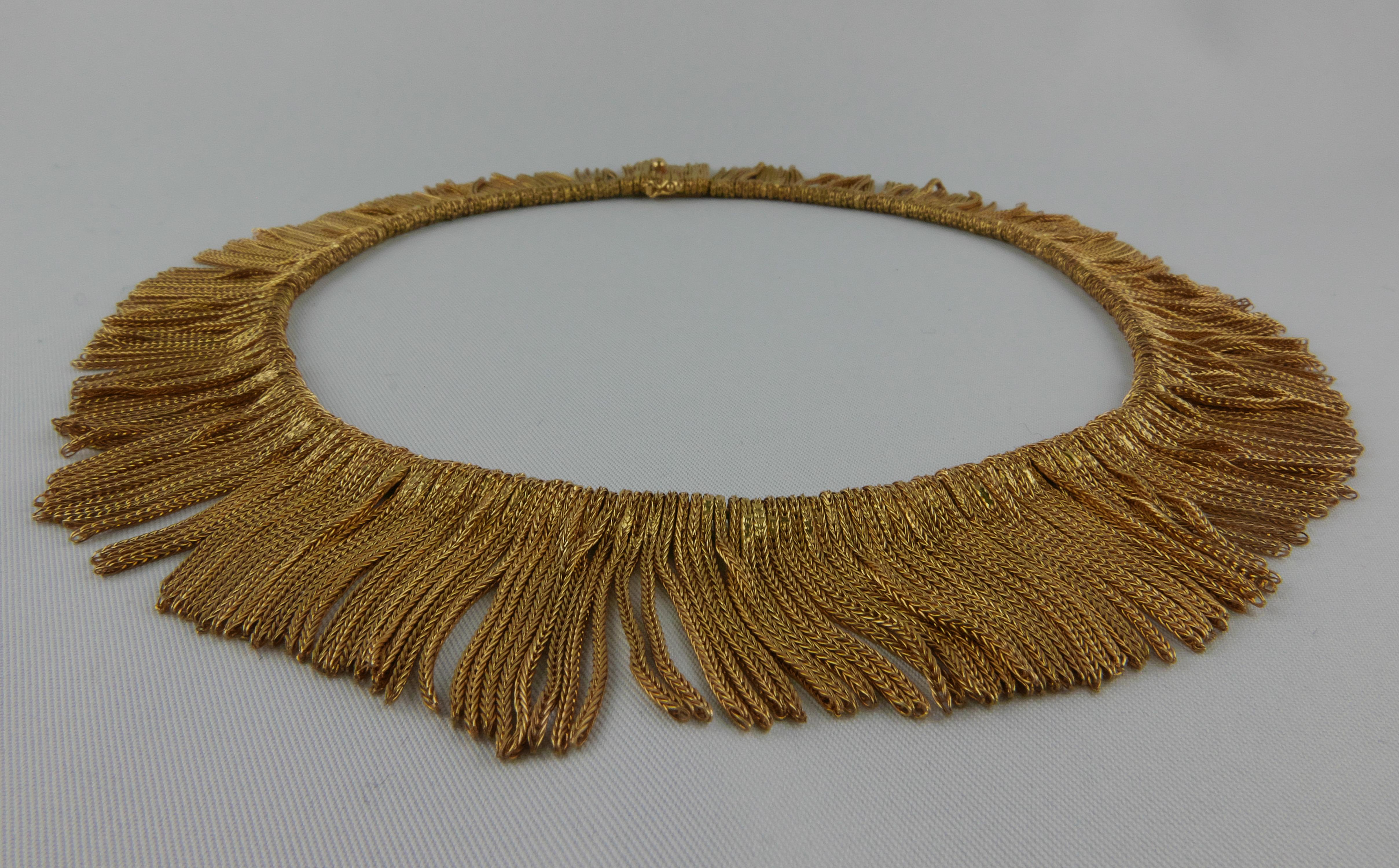 A 1970’s 18 kt Yellow Gold Necklace reminding the glamour of the 1920s with a silky effect. 
Of fringe design, the Necklace is a rich warm golden colour  composed of a multitude of graduating hand-twisted gold roping precisely interlocked to form a