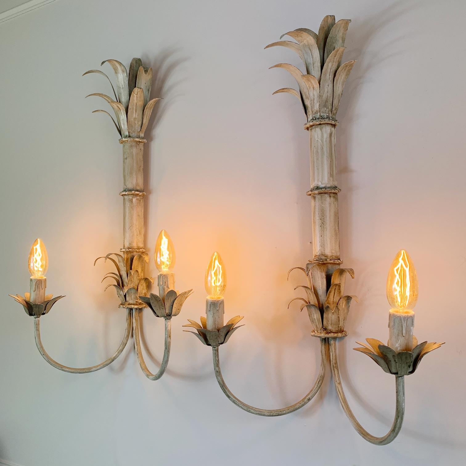 A statement pair of French toleware Palm Reed wall sconces, circa 1970s. Fabulous large sized sconces depicting faux bamboo reed stems with crowning palm fronds.The soft off white tone is original to the lamps.The lamps take an E14 bulb to each arm