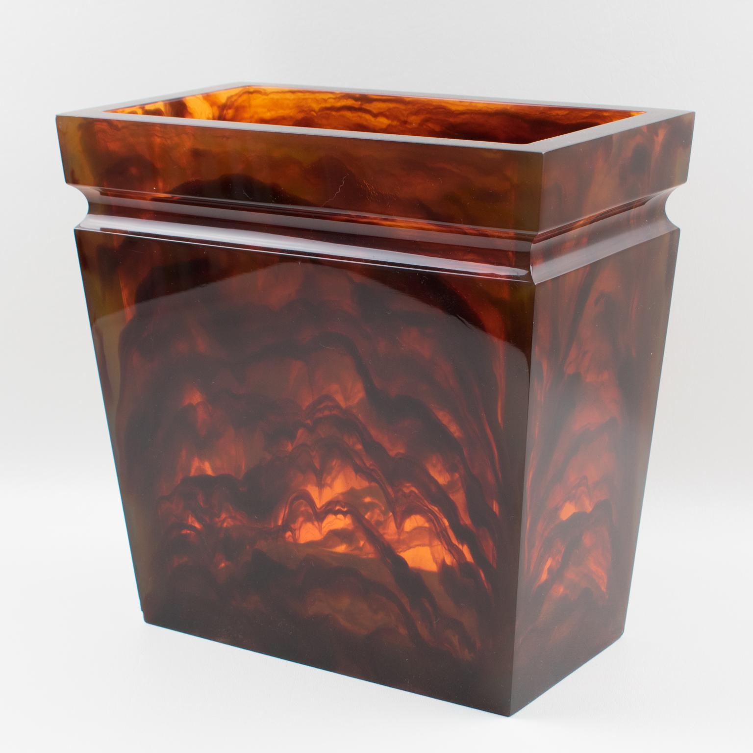 Stunning 1970s modernist tortoise Lucite paper waste basket. Tall rectangular shape extra thick walled sides. Gorgeous tortoiseshell pattern with red tea amber marble color and lots of translucency. No visible maker's mark.
Measurements: 11.25 in.