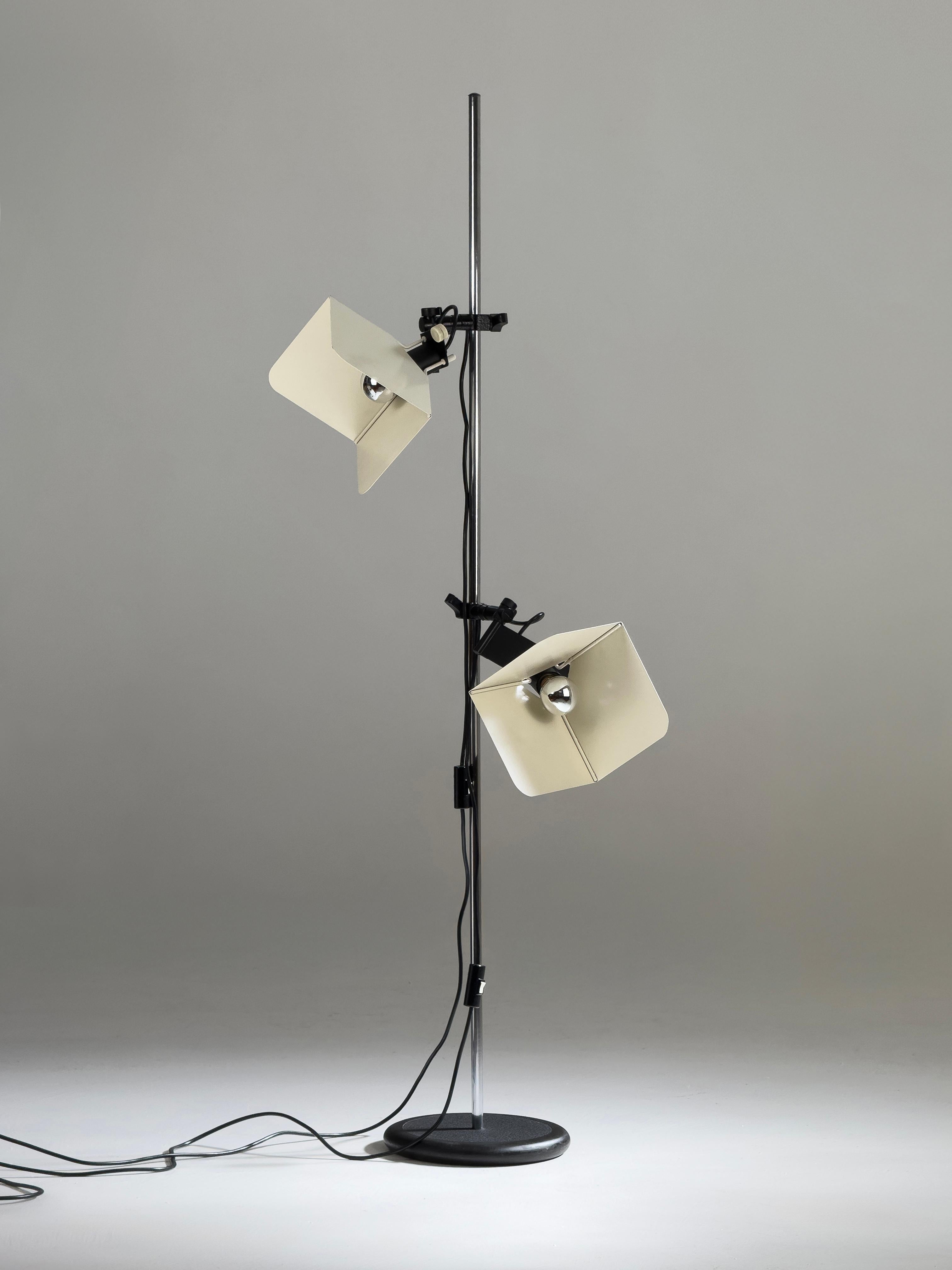The Triedro floor lamp, designed by Joe Colombo in 1970, evokes the precision and functionality of professional studio lighting. The lamp offered here is a 1970s piece, completely original and intact in every part. It features a glossy white