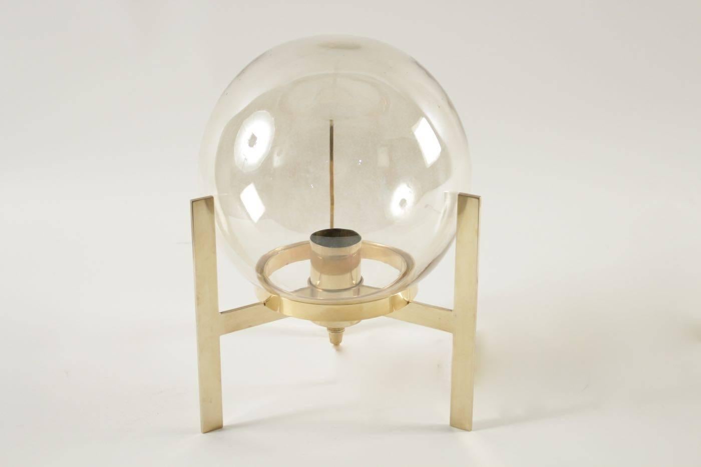 The base of the lamp is composed of 3 feet connected between them on which is posed a cylindrical circle and equipped with a socket, the whole in gilded brass.
On this one rests a large sphere in slightly iridescent blown glass.
1 bulb.

 