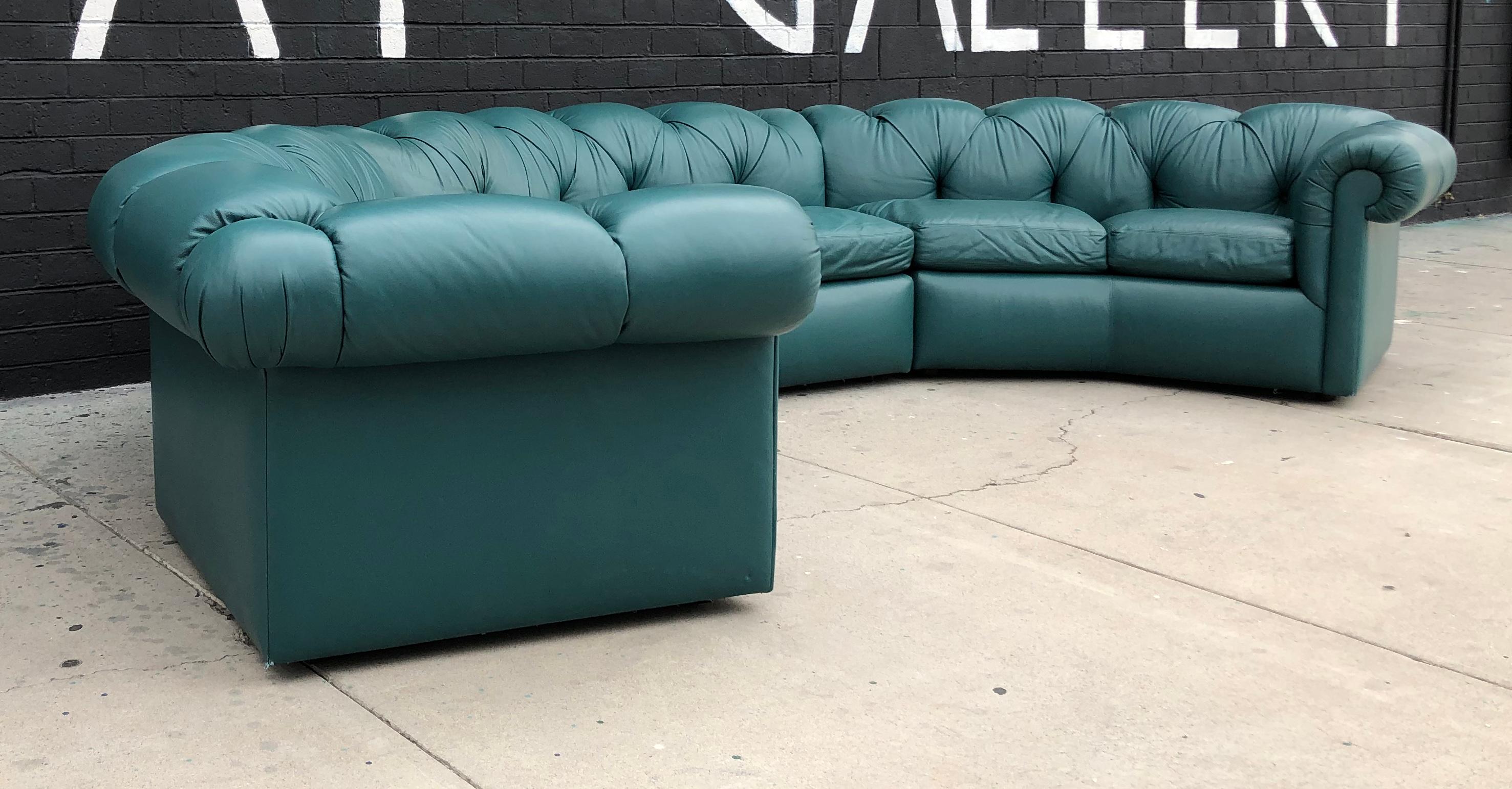 An absolutely stunning tufted leather sofa by A. Rudin. This 1970s sofa is a deep greenish blue turquoise color that's sure to bring a stylish pop of color to any environment. With a mid mod meets Hollywood Regency Chesterfield feel, this sofa is
