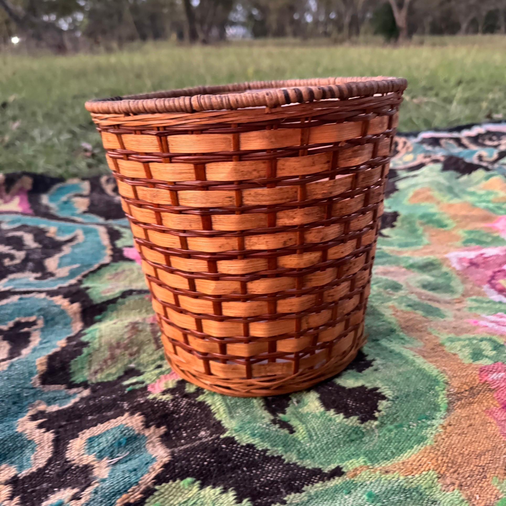 Two toned wicker rattan woven basket that has the original plastic lining. Can be used as a wastebasket or to hold a potted plant or even to use for storage. The weaving is in great shape. Has a brick or subway tile pattern to it, which is quite