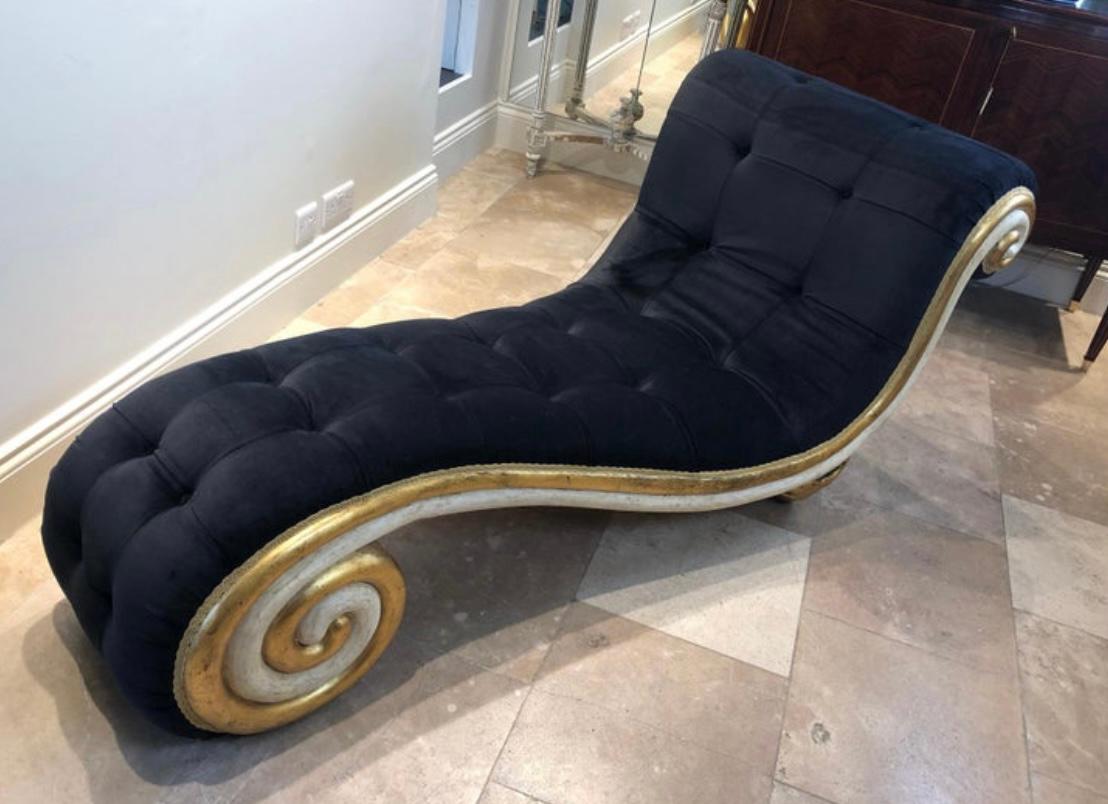 An extraordinary and unique chaise longe all hand carved with gilding and paintwork. This piece has been newly upholstered in buttoned midnight blue velvet, sitting on carved gilded seashells.

 