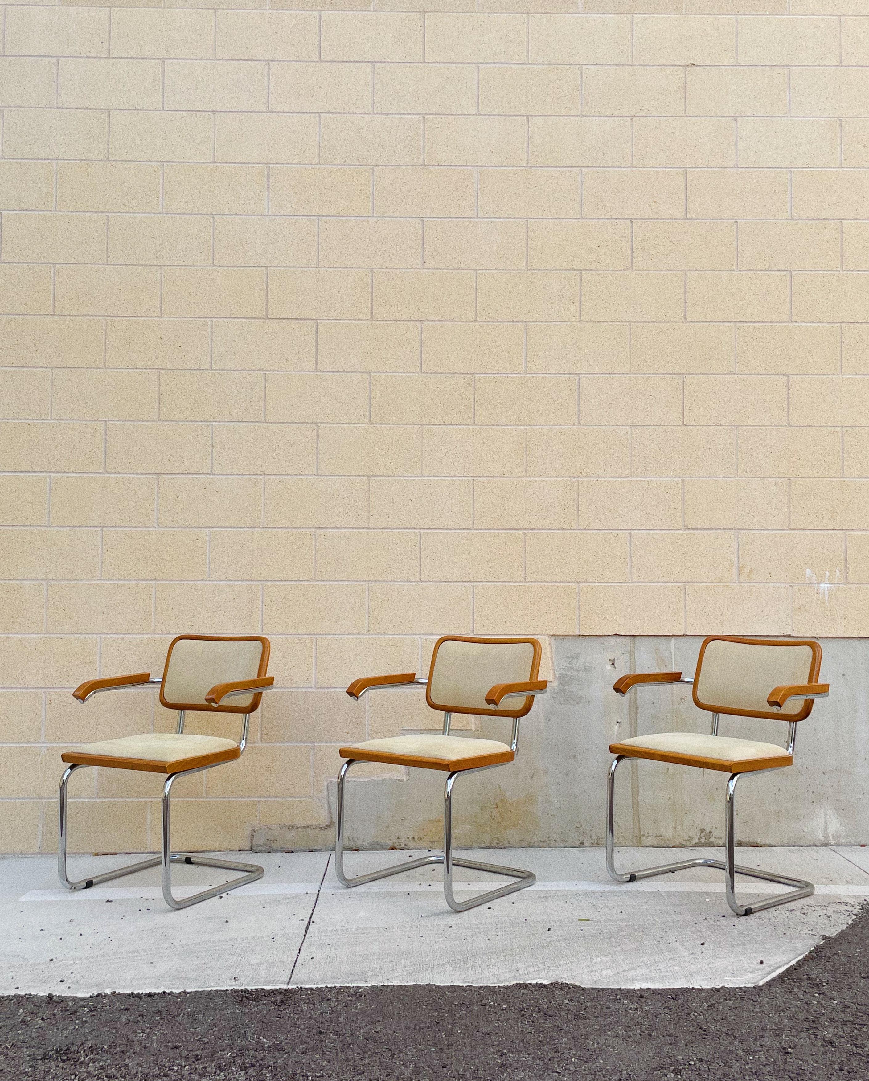 Upholstered Cesca Chairs after Marcel Breuer for Knoll; Made in Italy. Upholstered in a cream colored woven fabric with blue, peach weaving throughout.