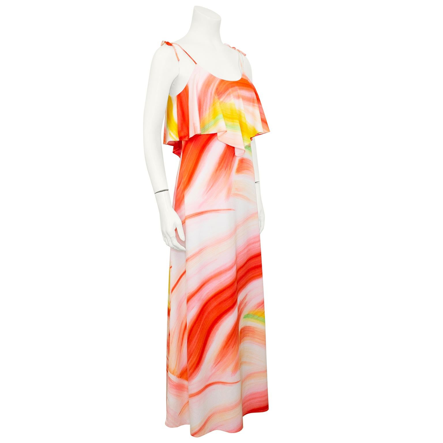 Ursula of Switzerland poly jersey maxi dress from the 1970s featuring an orange, yellow and green abstract paint brush print. Scoop neckline with spaghetti straps that tie. Tiered hanky hem bust. Skirt hits the floor or just above depending on your