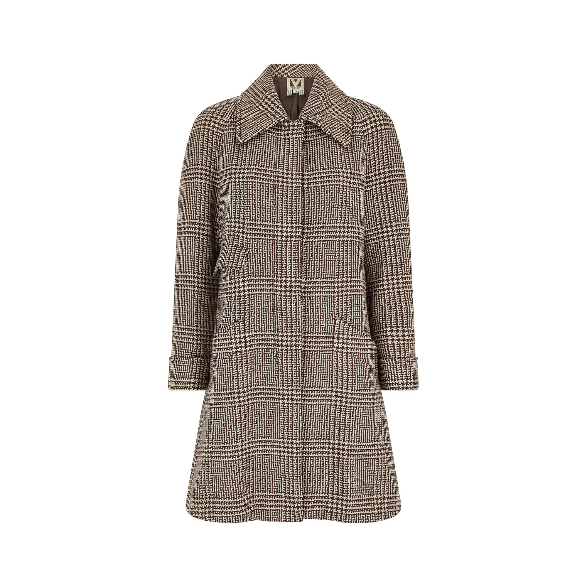 This early 1970s houndstooth cape jacket is a rare and early example of one of Valentino Garavani's ready to wear designs.  After his success as a couturier in 1962, he opened Valentino Boutique shops in Milan and Rome in 1969; the New York branch